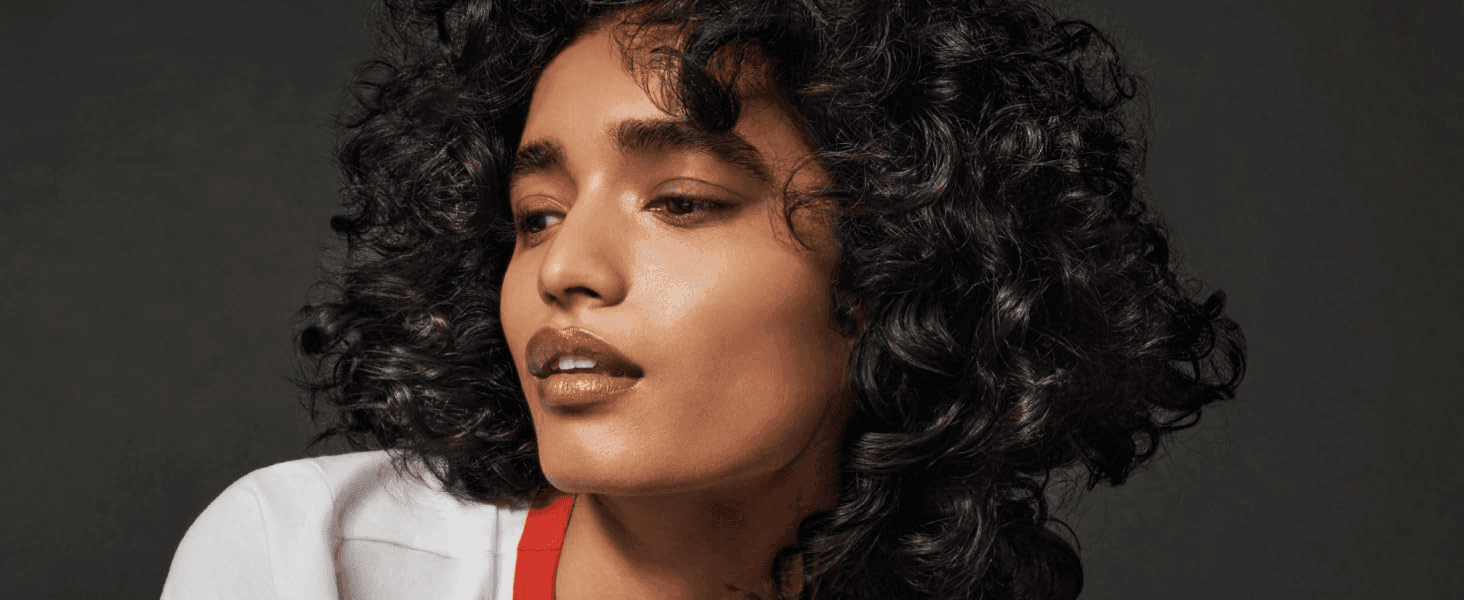 Shows healthy, defined curls on a real model so shoppers picture the hair result they want.
