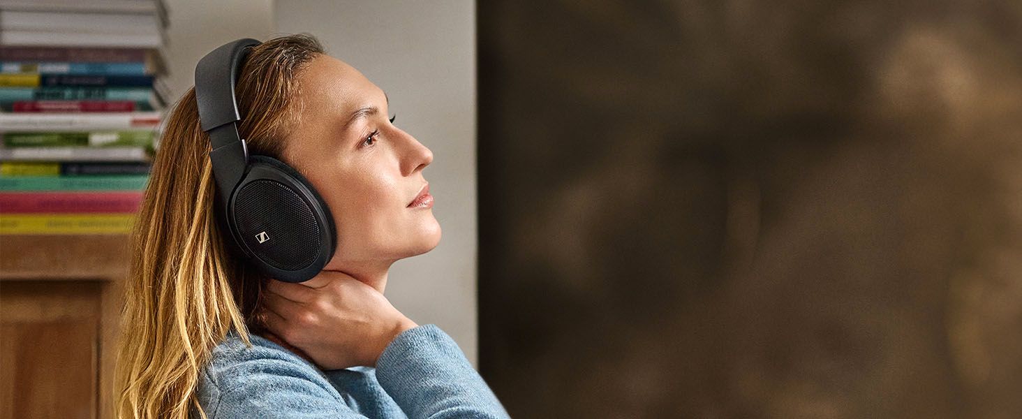 Shows a woman relaxing in a home setting with the headphones on to help shoppers picture everyday comfortable listening.