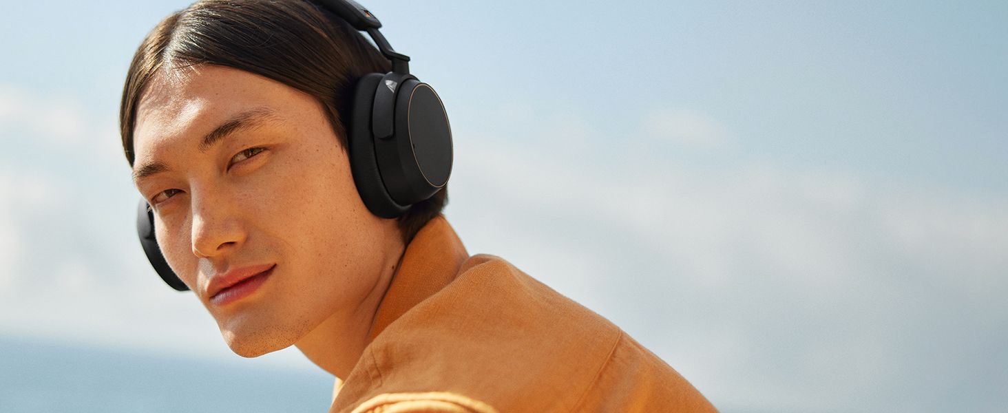 Shows a man wearing the headphones outdoors to help shoppers picture them as part of an active, everyday lifestyle.
