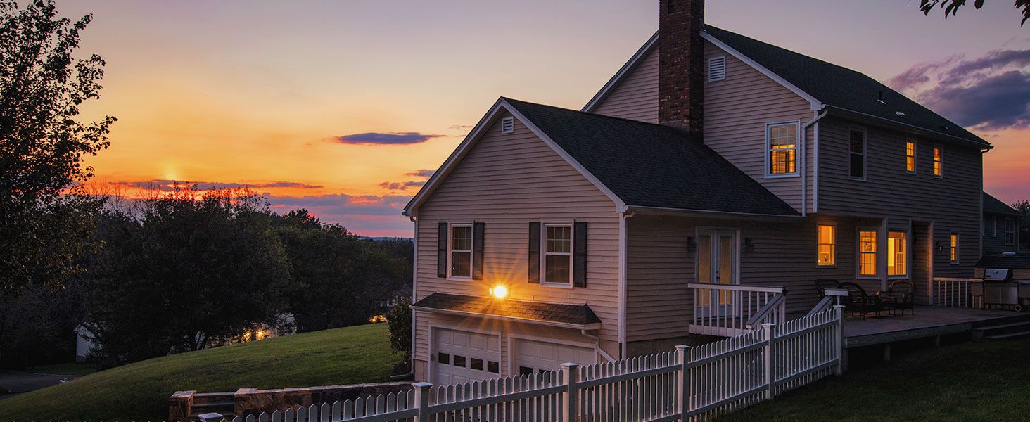 Shows the product in a real home exterior at dusk to help shoppers picture the warm glow of the lights in everyday life.