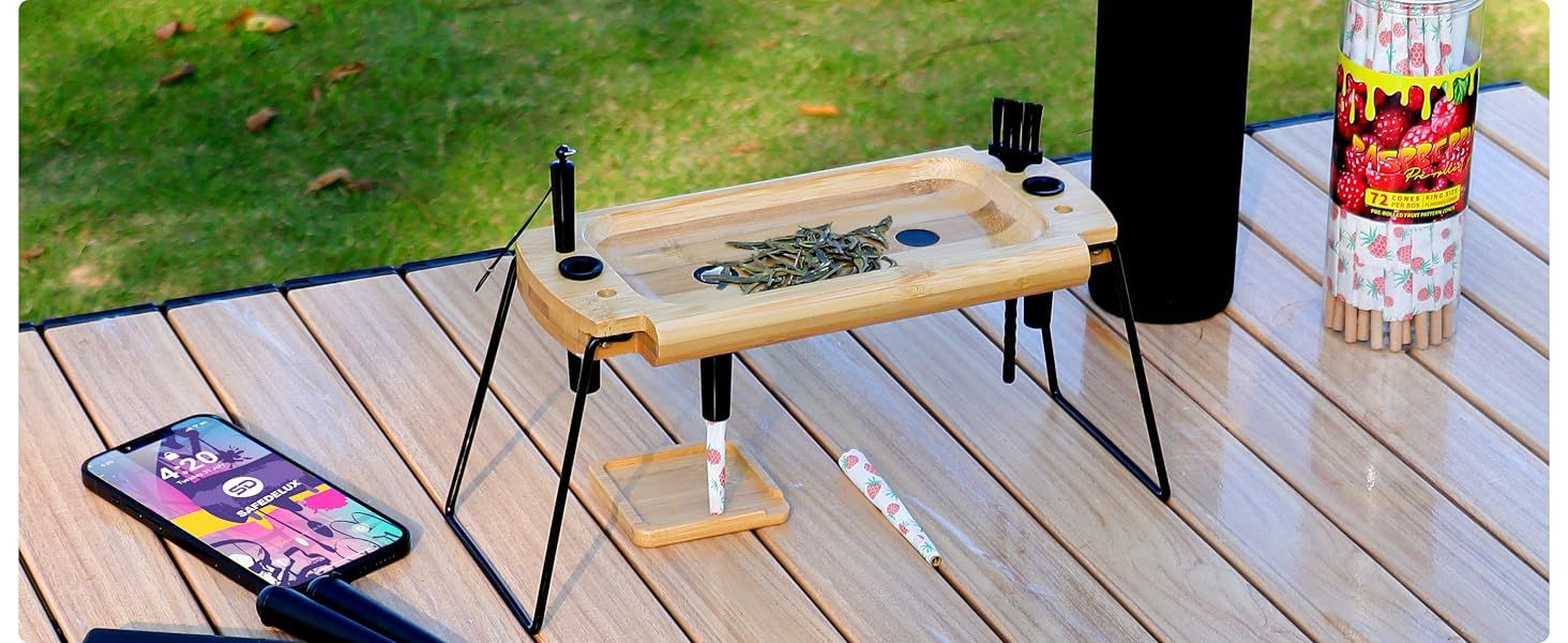 Shows the folding tray in an outdoor camping setting to suggest it works on the go in multiple places. Demonstrates the tray set up on folding legs so shoppers see how simple it is to use anywhere.