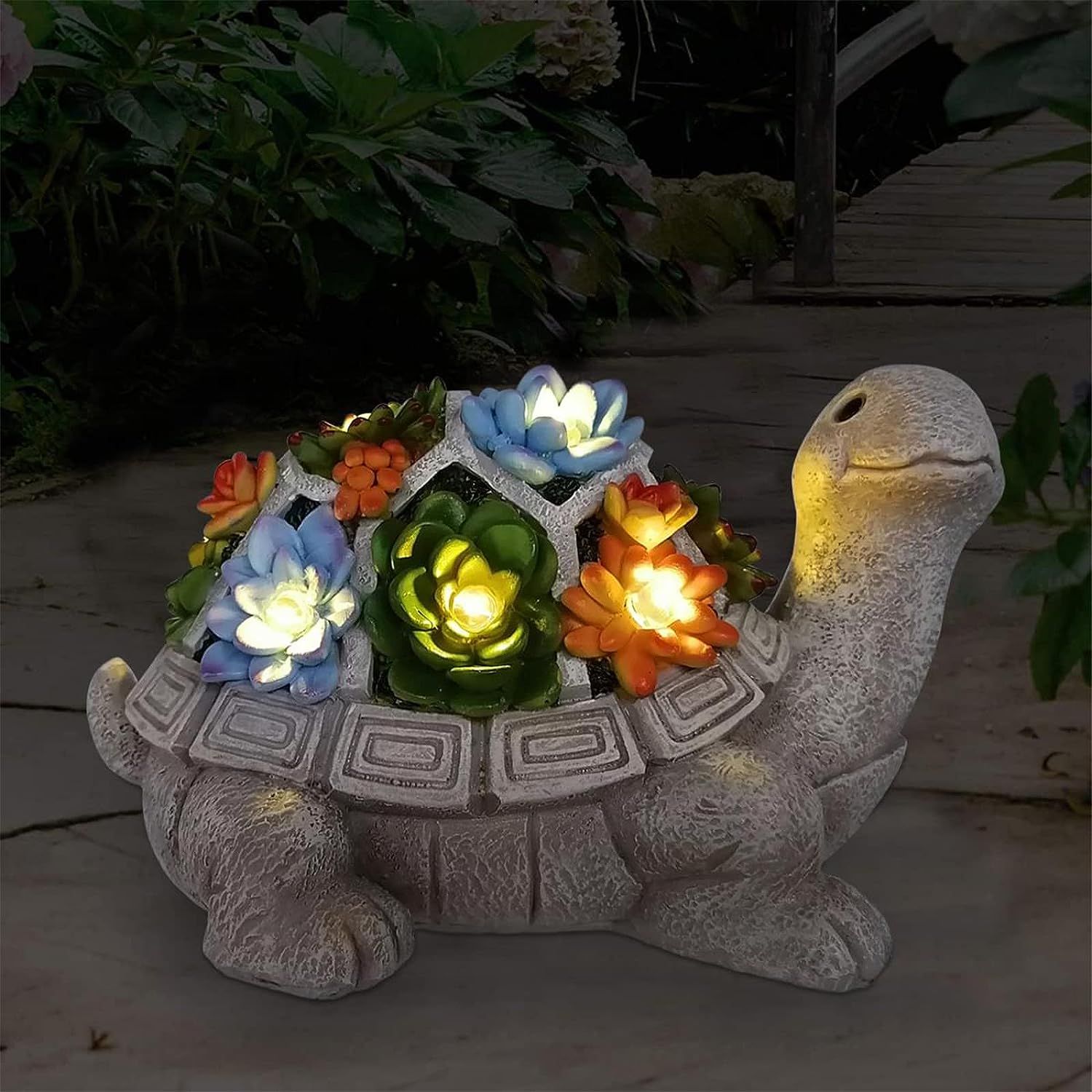 Shows the core product, a decorative turtle garden ornament with illuminated flowers, displayed in a real outdoor setting to help shoppers visualize its appearance and lighting feature. Demonstrates…