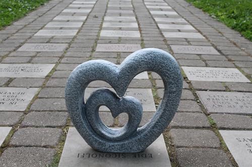 Shows the product in an outdoor memorial or garden setting to help shoppers visualize how the decorative sculpture looks in a real-world environment.