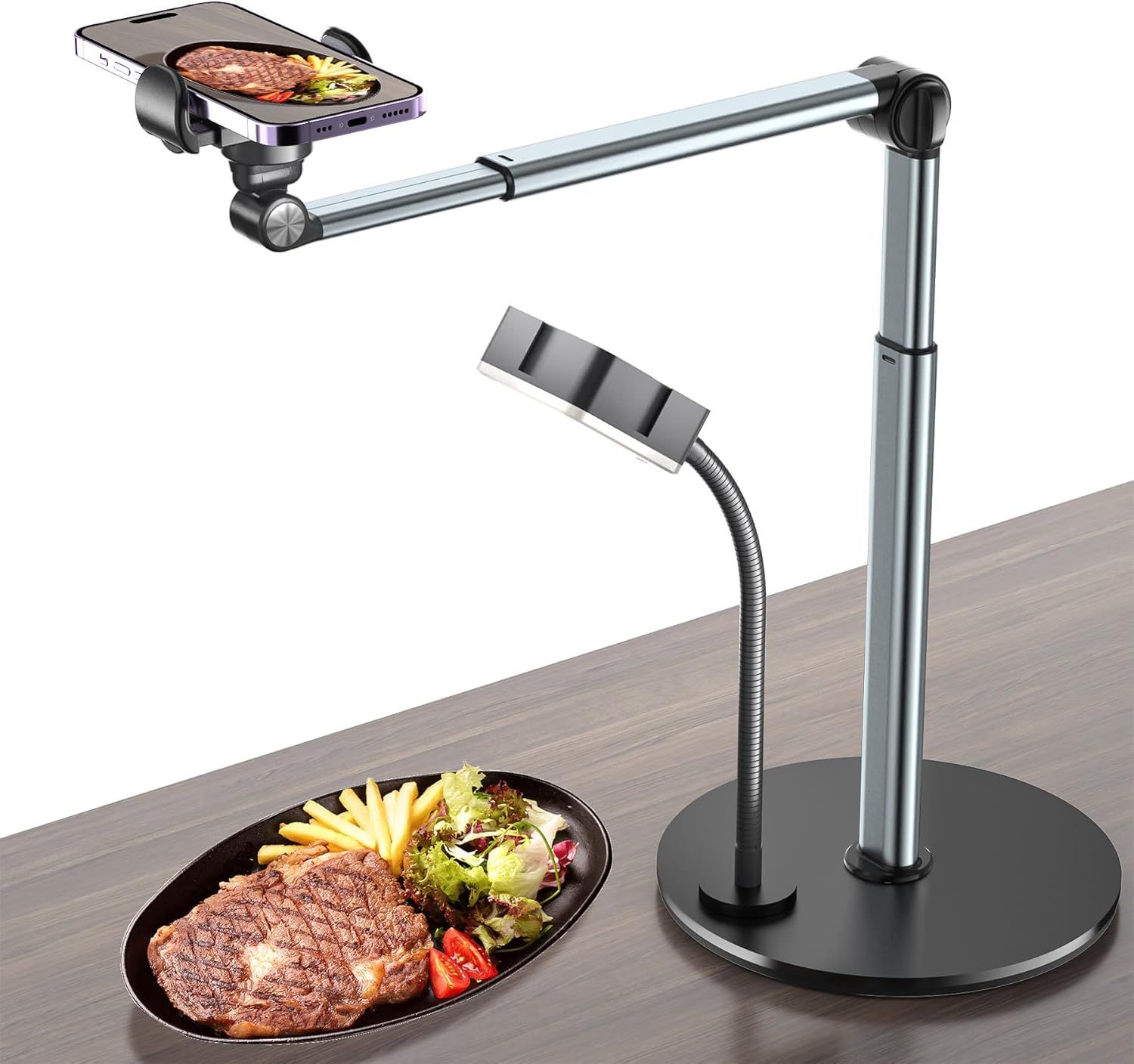 Demonstrates how the phone mount stand works for overhead food photography or content creation, showing the adjustable arm positioning the phone directly above a meal. Shows the product in a…