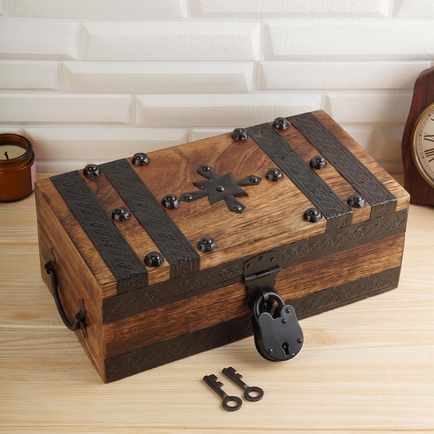 Shows the wooden chest as the core item with its vintage metal studs, straps, and lock hardware visible so shoppers understand its look and build. Shows the included black padlock and two antique…