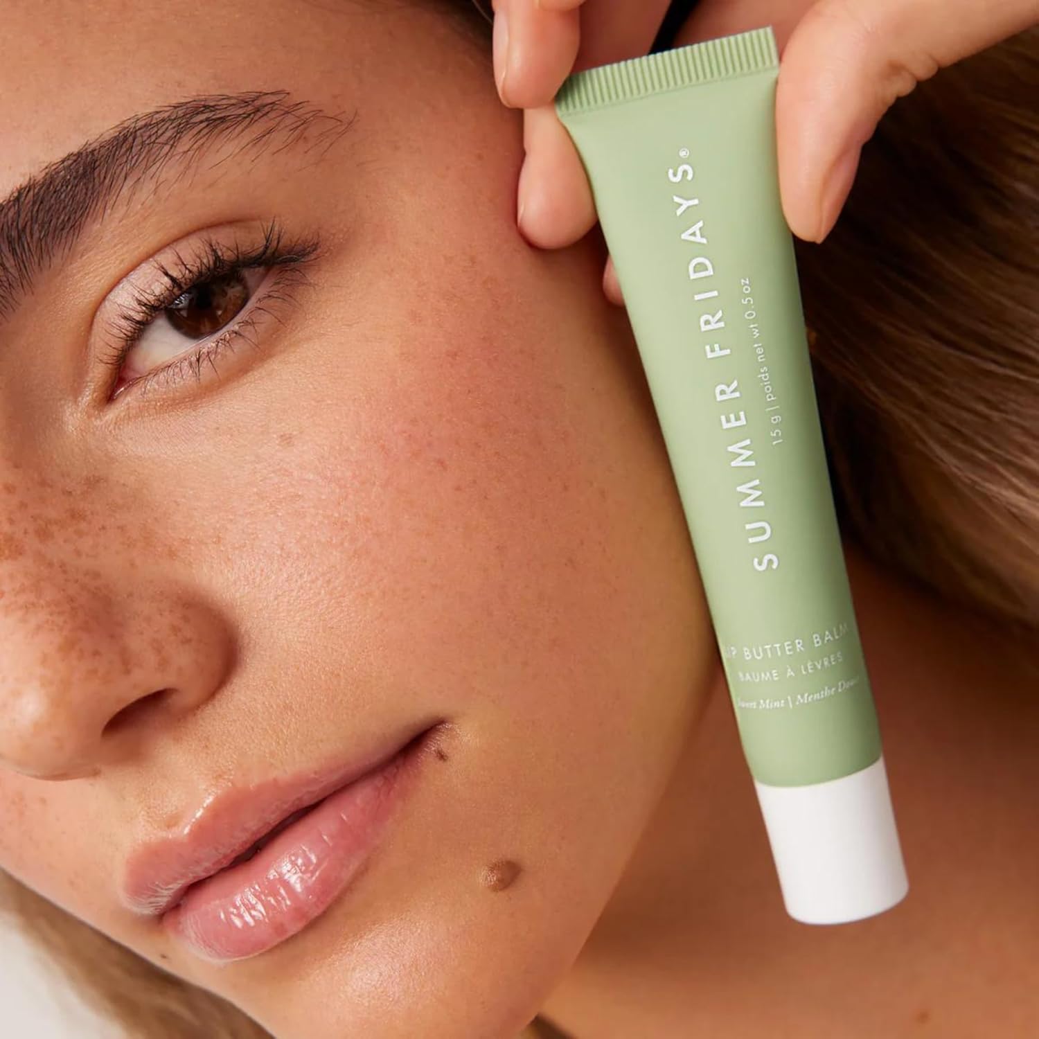 Showcases the lip balm's moisturizing effect by displaying the product next to a close-up of smooth, hydrated lips.