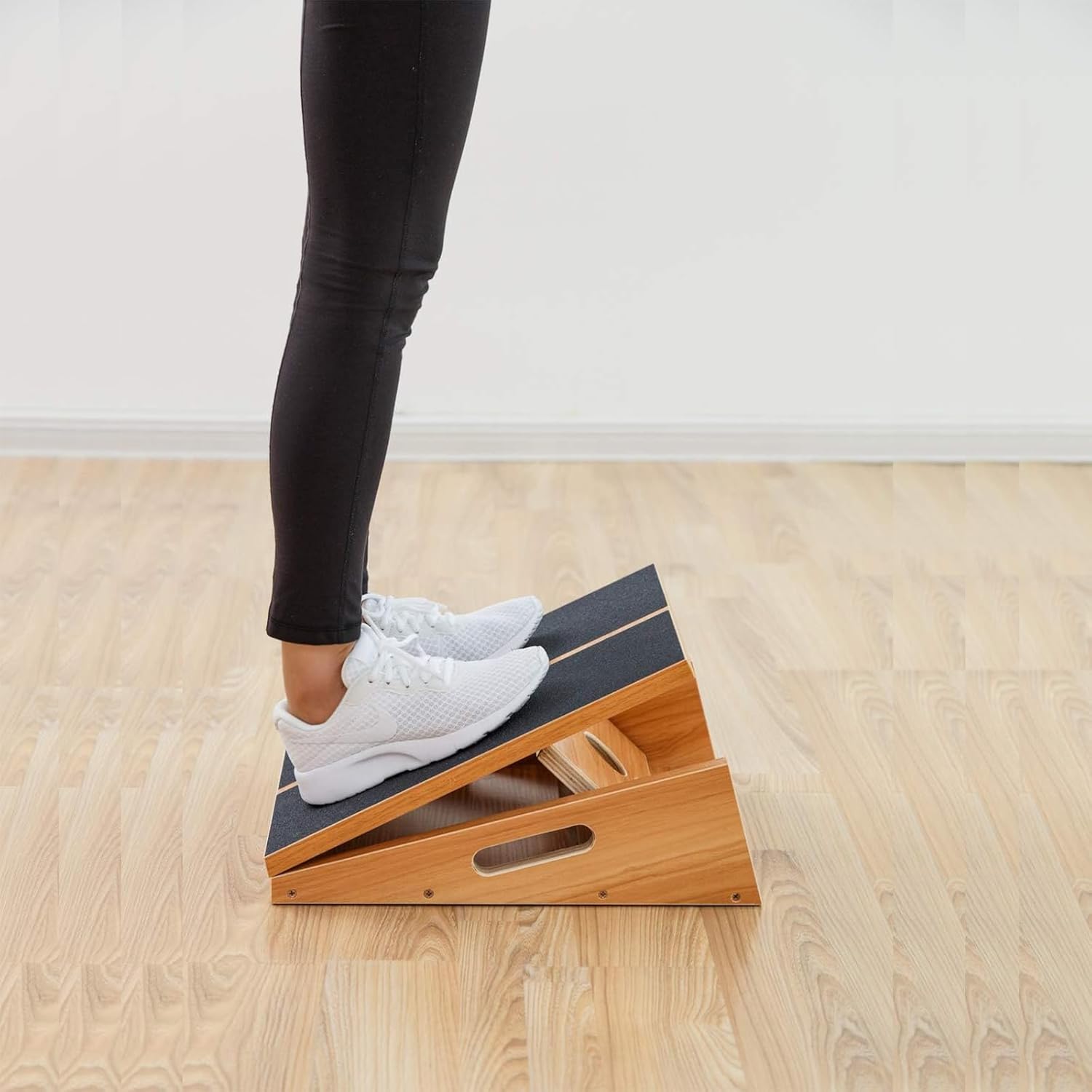 Demonstrates how to use the product for stretching calf muscles, showing proper foot placement and angle.
