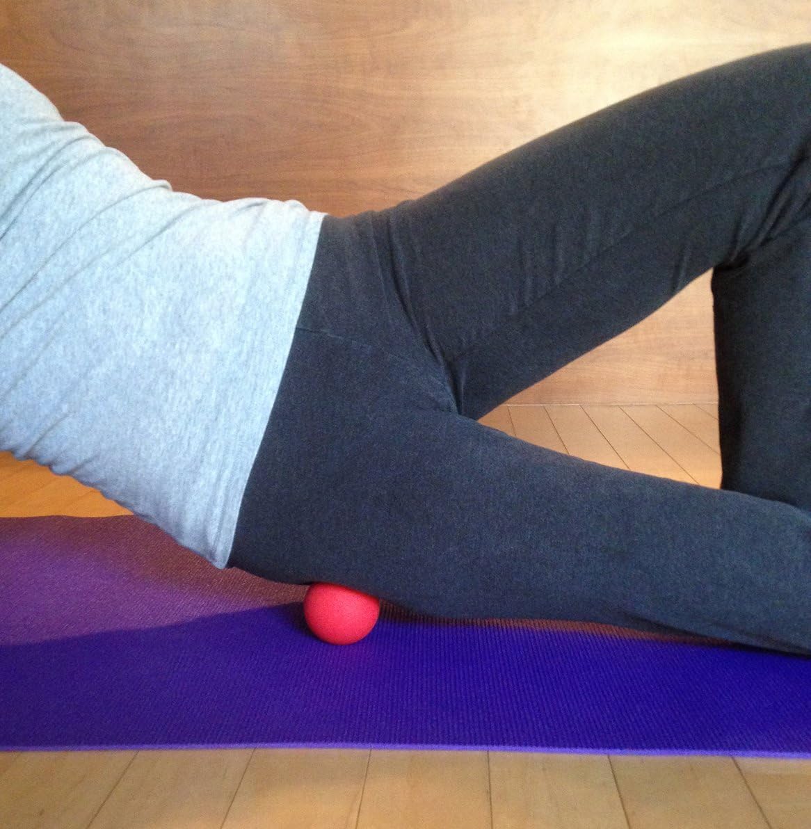 Demonstrates how to use a massage ball for muscle recovery or self-massage techniques, likely targeting the hip or thigh area.