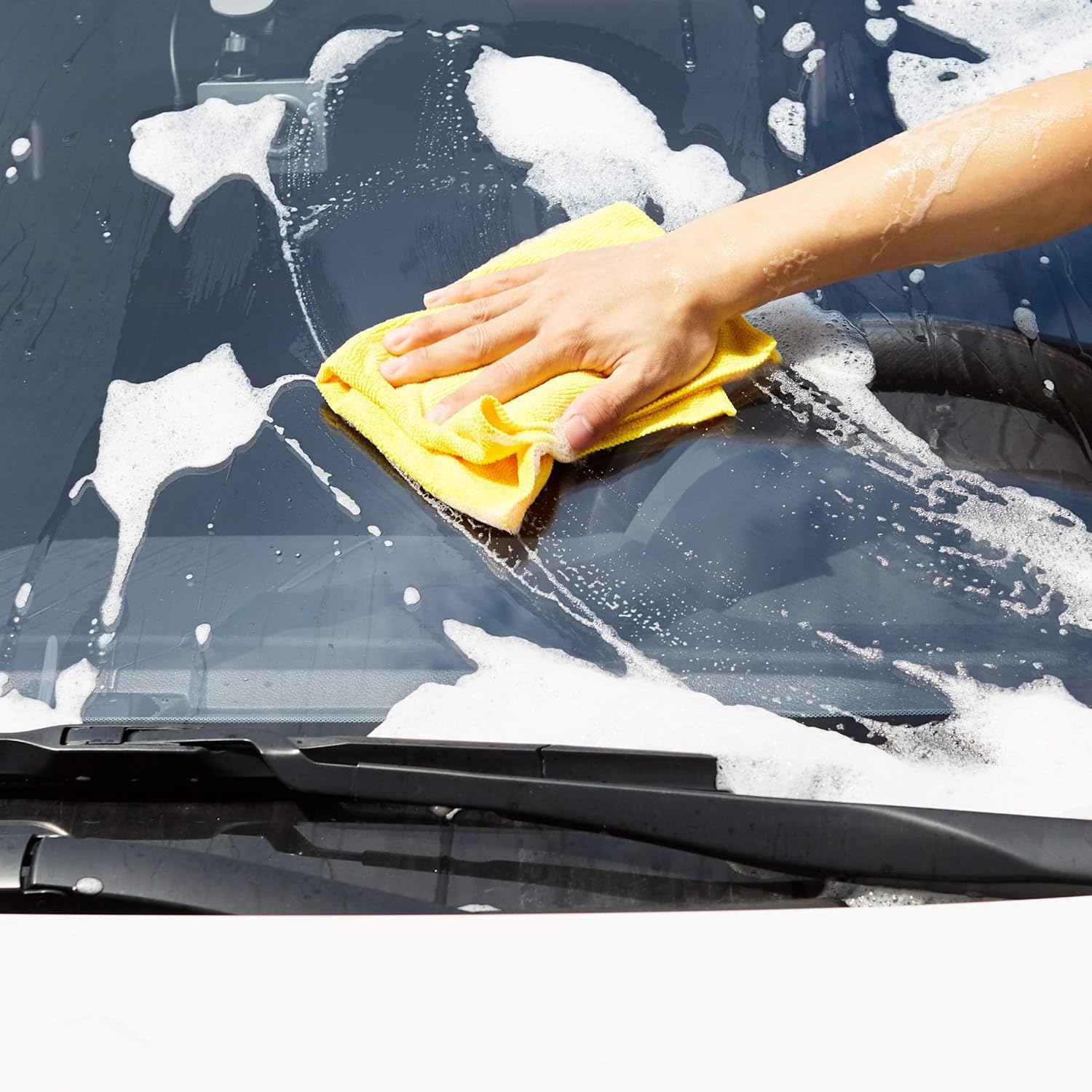 Demonstrates the proper technique for washing a car windshield, showing the product in use to clean effectively.