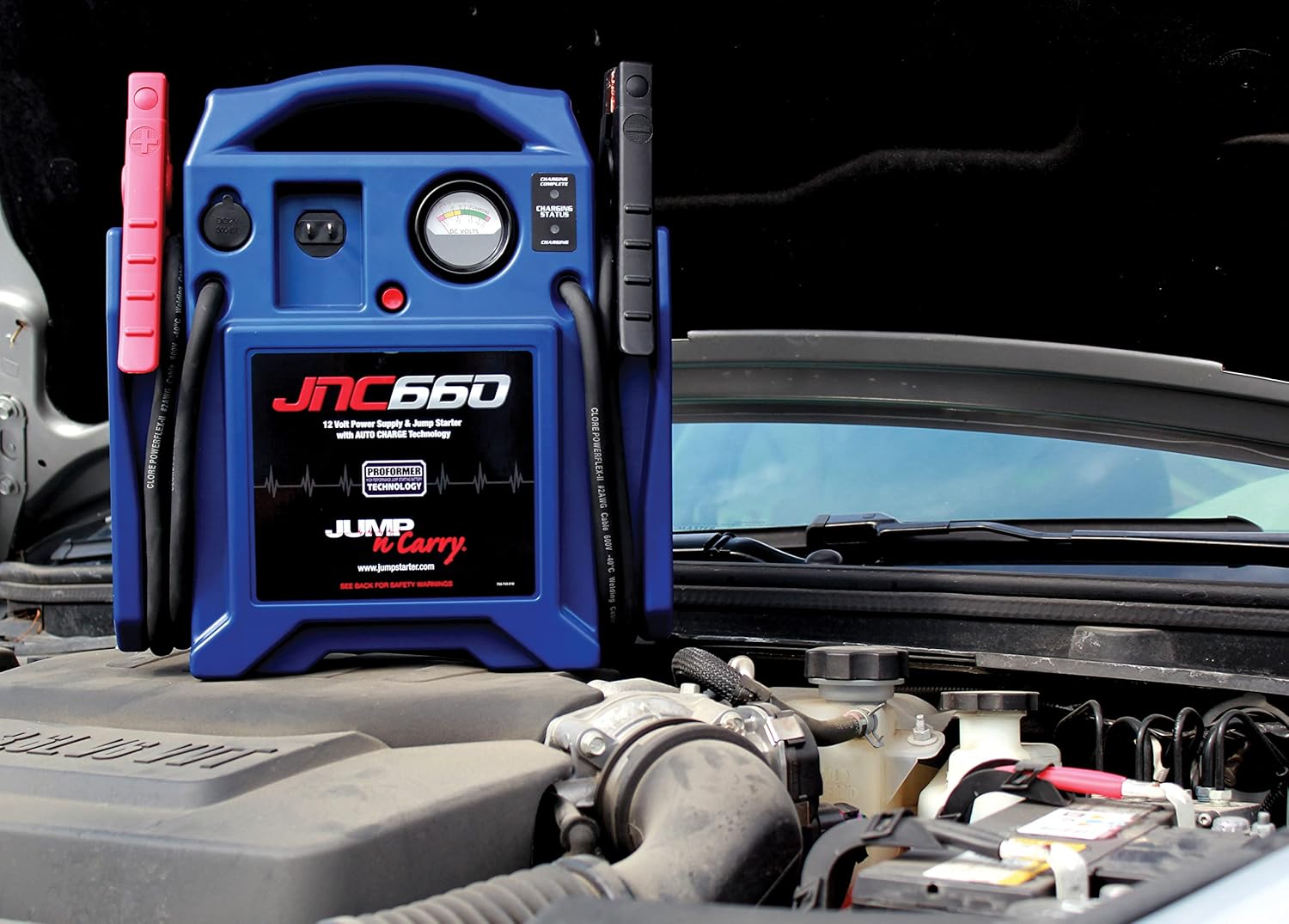 Shows the product being used as a jump starter for a car, demonstrating its practical application in automotive emergencies.