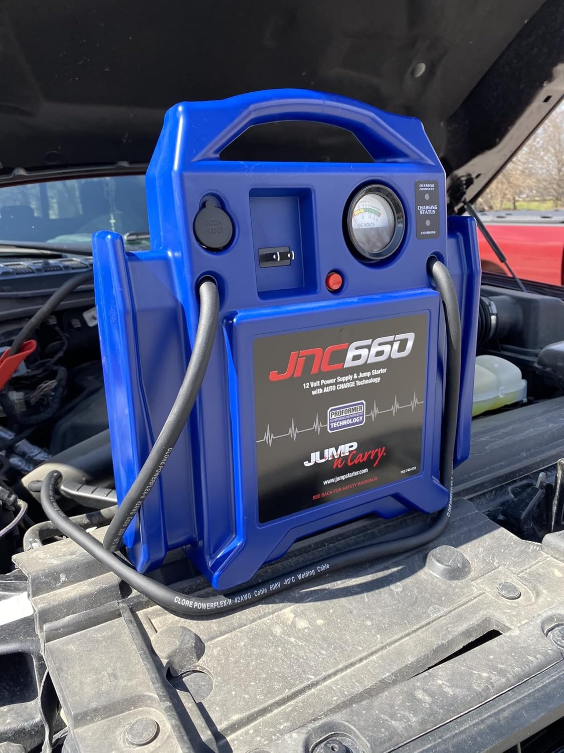 Demonstrates the product being used to jump start a car battery, showcasing its practical application in automotive emergencies.