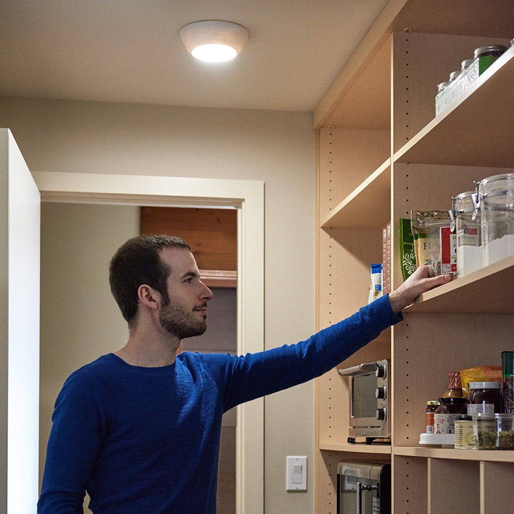 Shows the product in use within a real-world context, demonstrating how it provides illumination in a pantry or storage area.
