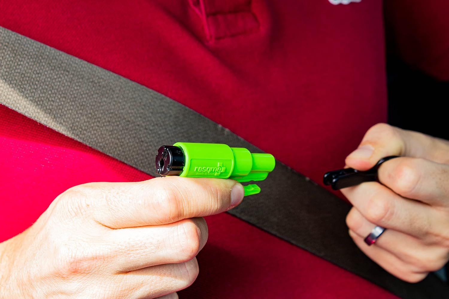 Demonstrates how to properly hold and use the seatbelt cutter tool in an emergency situation.