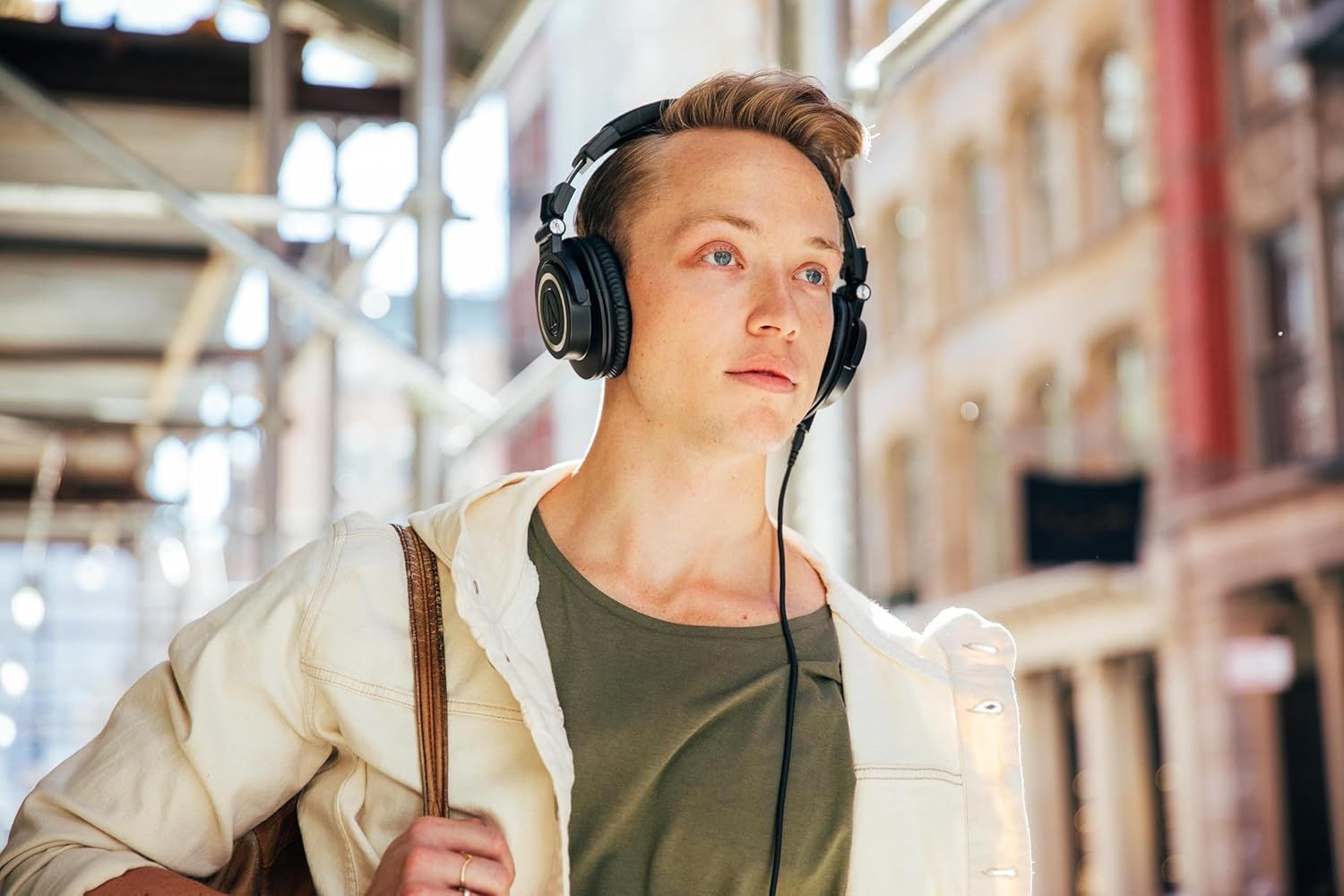Shows the headphones being used naturally by a person in an everyday setting to help shoppers visualize themselves using the product.
