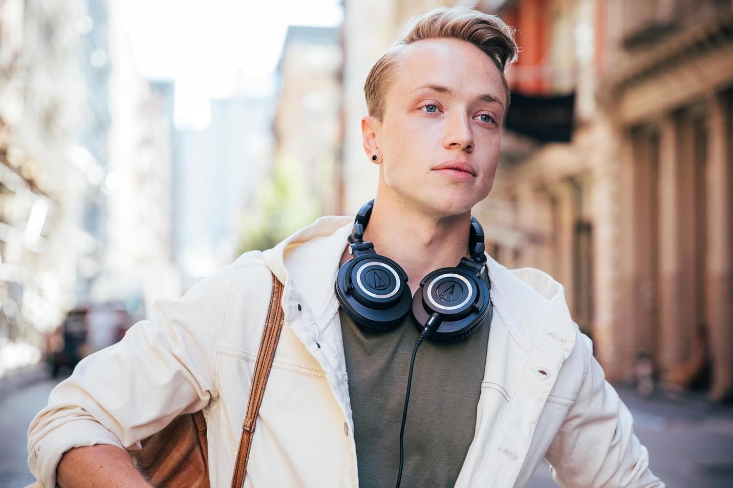 Shows the product being worn in a real-world urban setting to help shoppers visualize how the headphones fit into their daily lifestyle and commute.