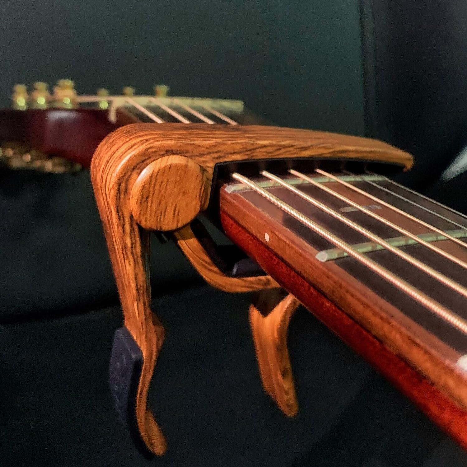 Showcases the high-quality wood grain and craftsmanship of the guitar capo to emphasize premium materials and aesthetic appeal.