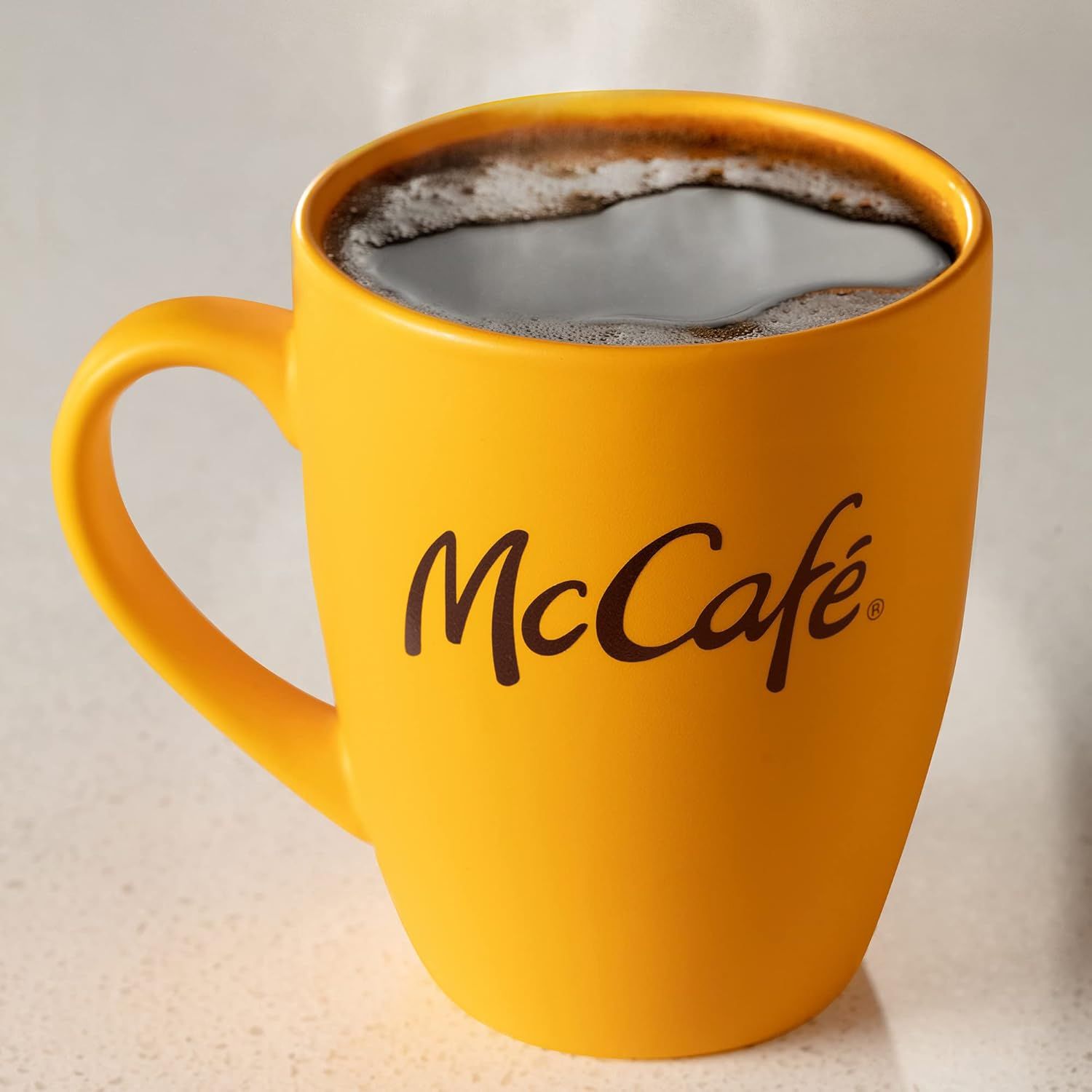 Emphasizes the McCafe brand through prominent logo placement on the mug to build brand recognition and trust with shoppers.