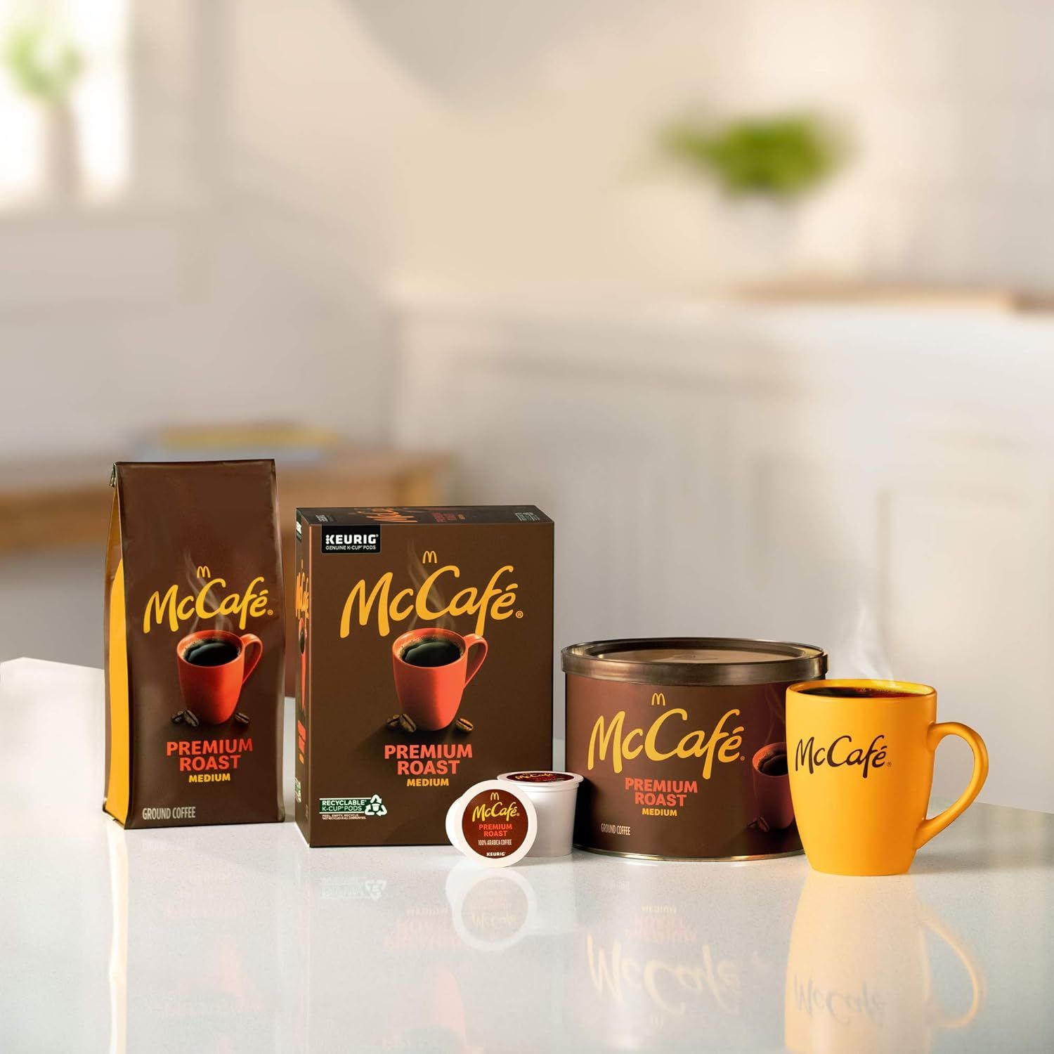 Shows the variety of McCafe Premium Roast coffee formats available including ground coffee bag, K-Cup box, canister, individual K-Cup pod, and branded mug to…