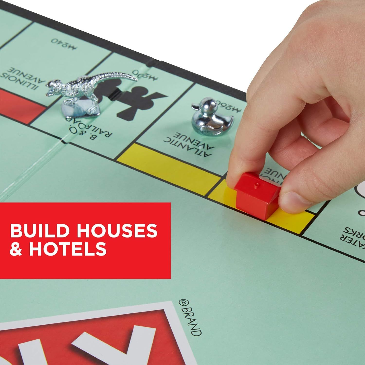 Demonstrates how to play the game by showing the action of building houses and hotels on properties, helping shoppers understand the core gameplay mechanic.…