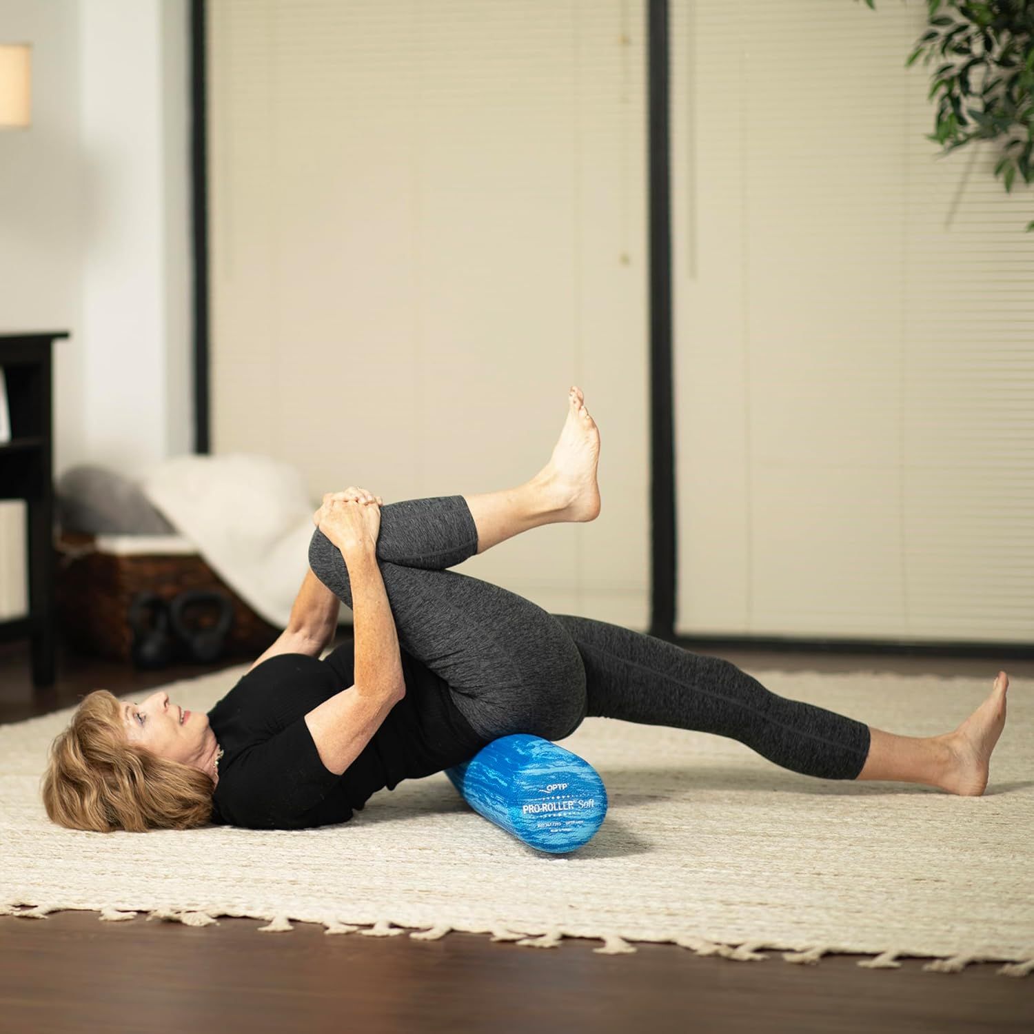 Demonstrates the product being used in a real-world home fitness setting to help shoppers visualize how the foam roller fits into their exercise routine.