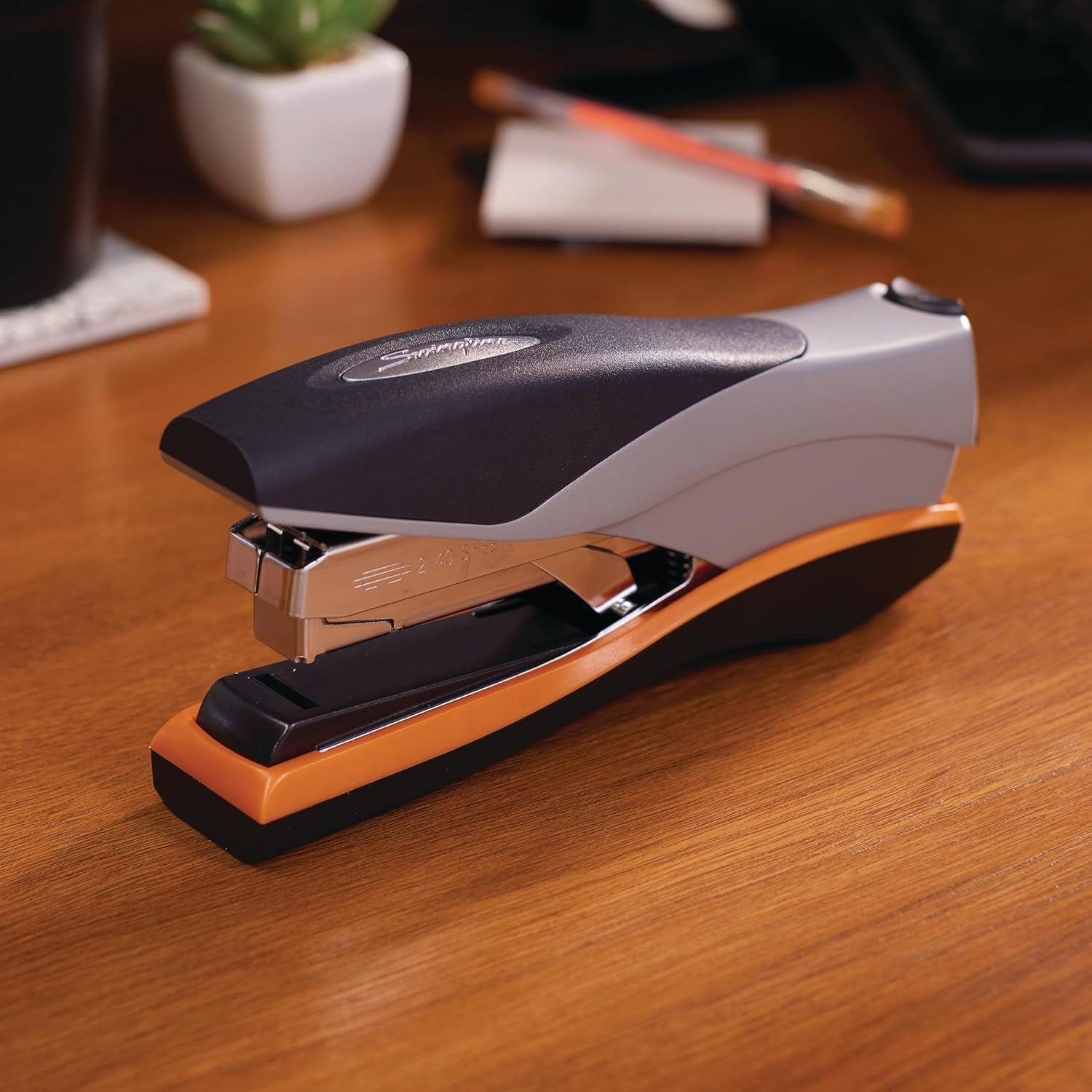 Showcases the product in a real-world office setting to help shoppers visualize the stapler on their own desk, creating contextual relevance and appeal.