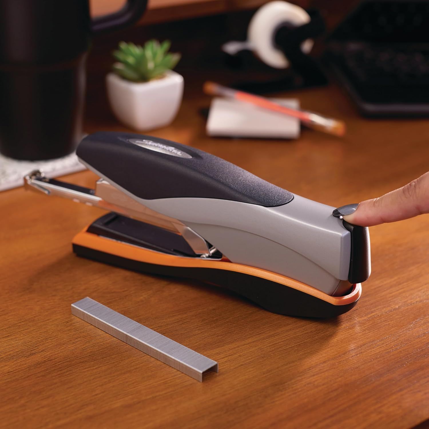 Shows the stapler in a natural office setting to help shoppers visualize the product in their own workspace and understand its professional aesthetic.