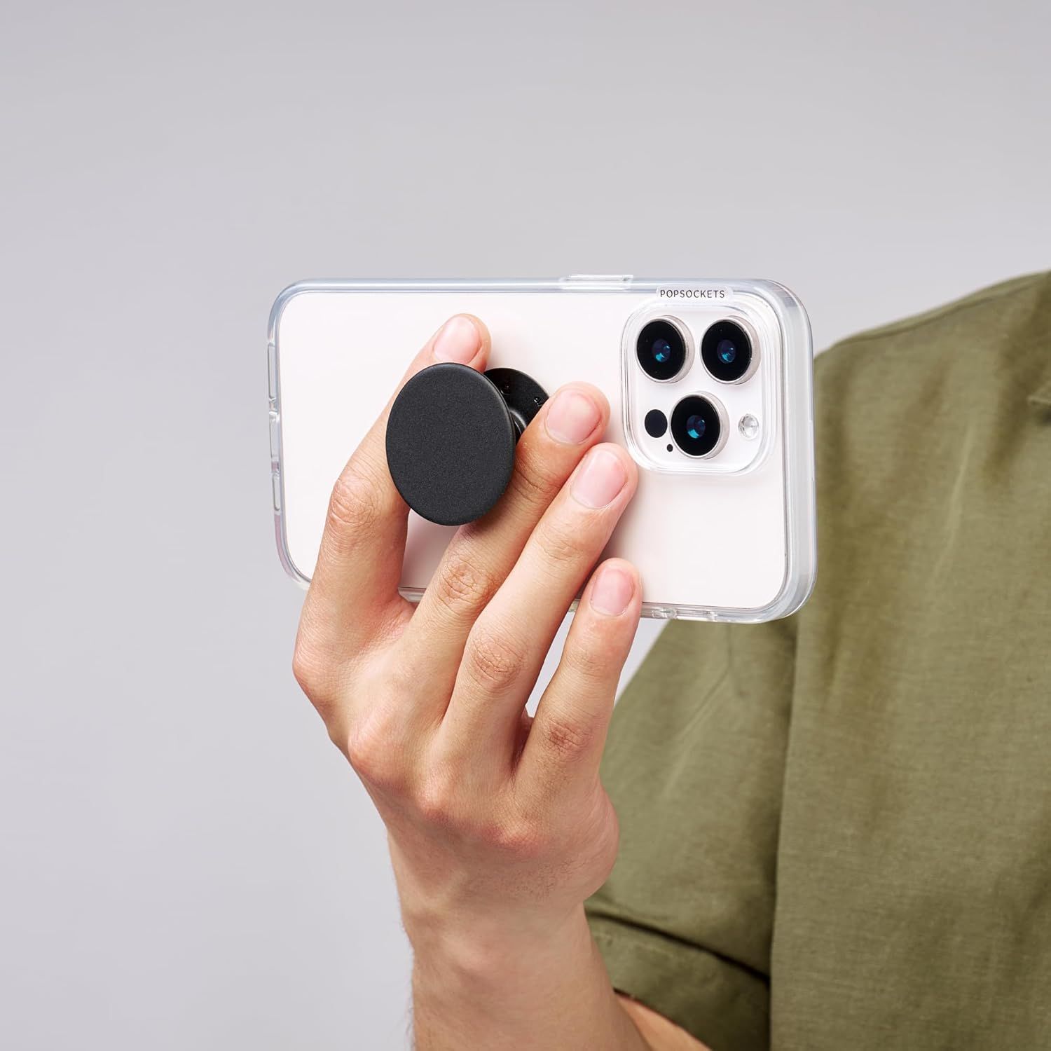 Shows authentic customer usage of the phone case with PopSocket grip in a real home setting, demonstrating how the product looks and functions in everyday life to build trust and relatability.