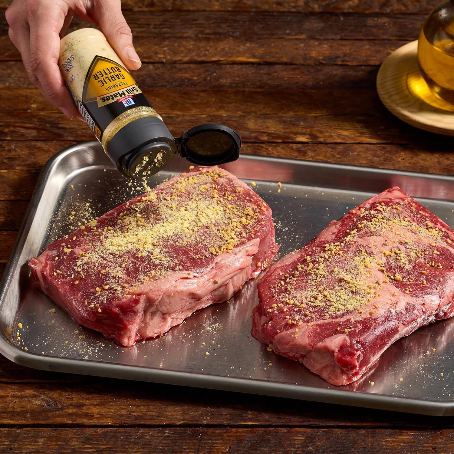 Demonstrates how to use the garlic butter seasoning product by showing it being applied to raw steaks, illustrating a practical cooking application. Shows the…