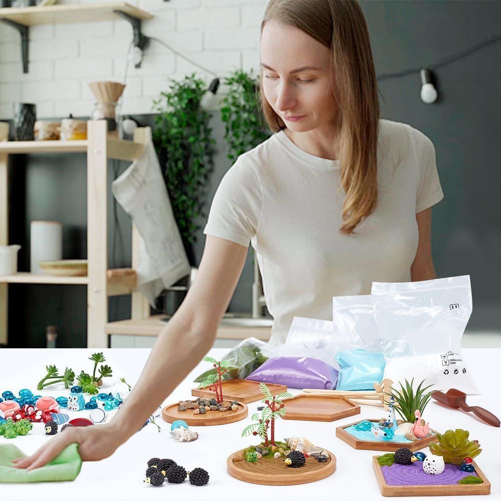 Shows everything included in the kit—wooden trays, colored sand, decorative elements, plants, and accessories—to help shoppers understand the complete value…