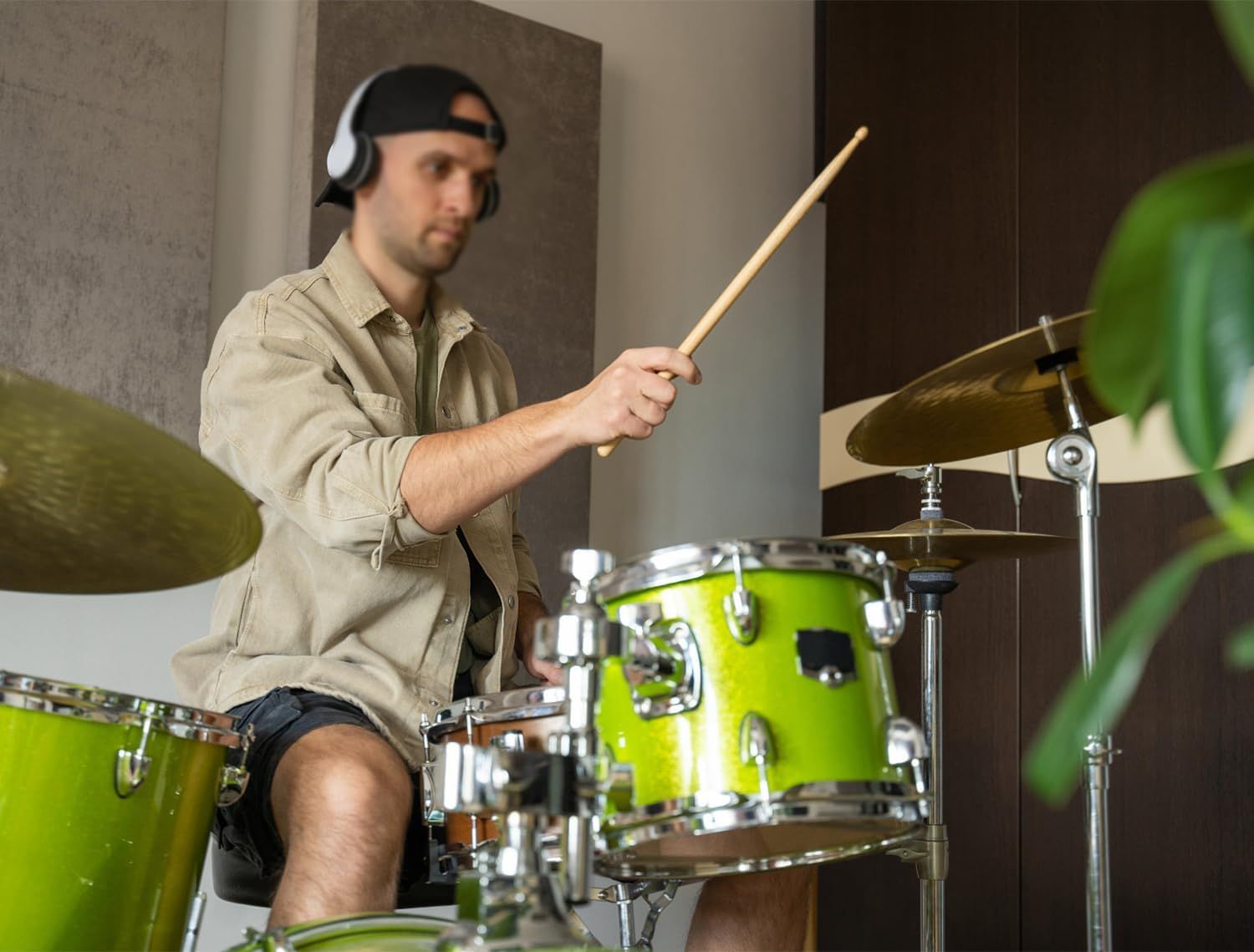 Demonstrates the product (headphones) being used in a real-world musical context, showing the product in action during drumming to help shoppers visualize practical use.