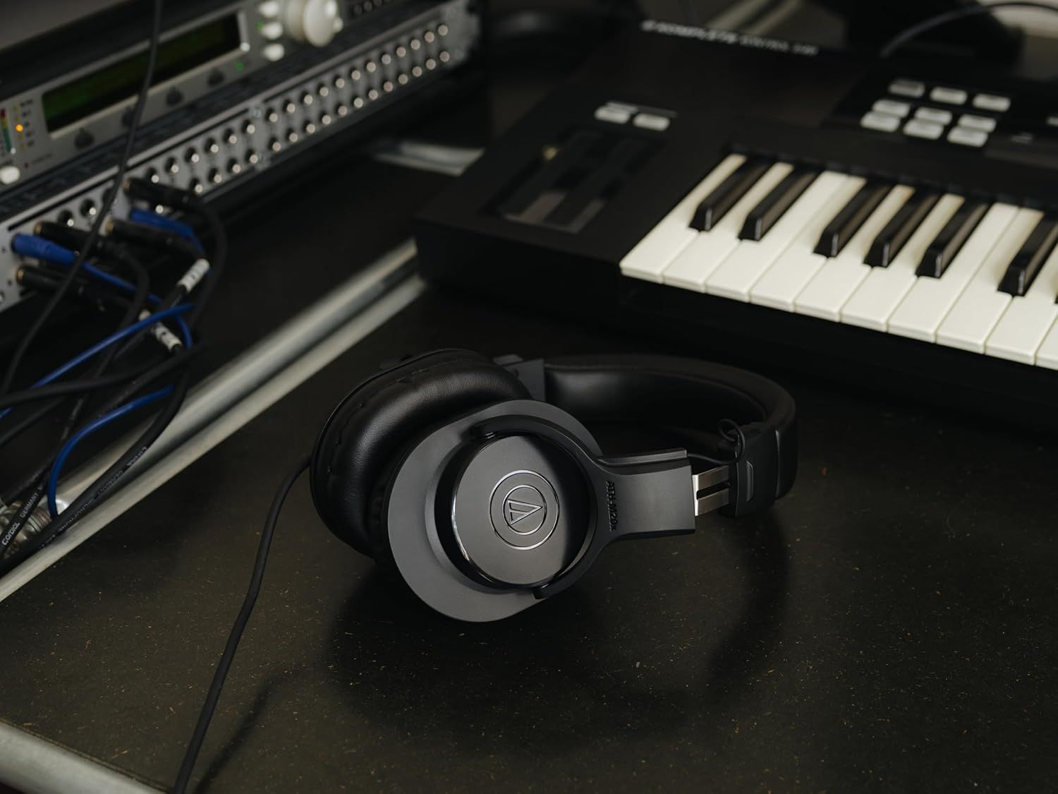 Demonstrates the headphones in a real-world professional music production setting to help shoppers visualize the product in use with studio equipment.