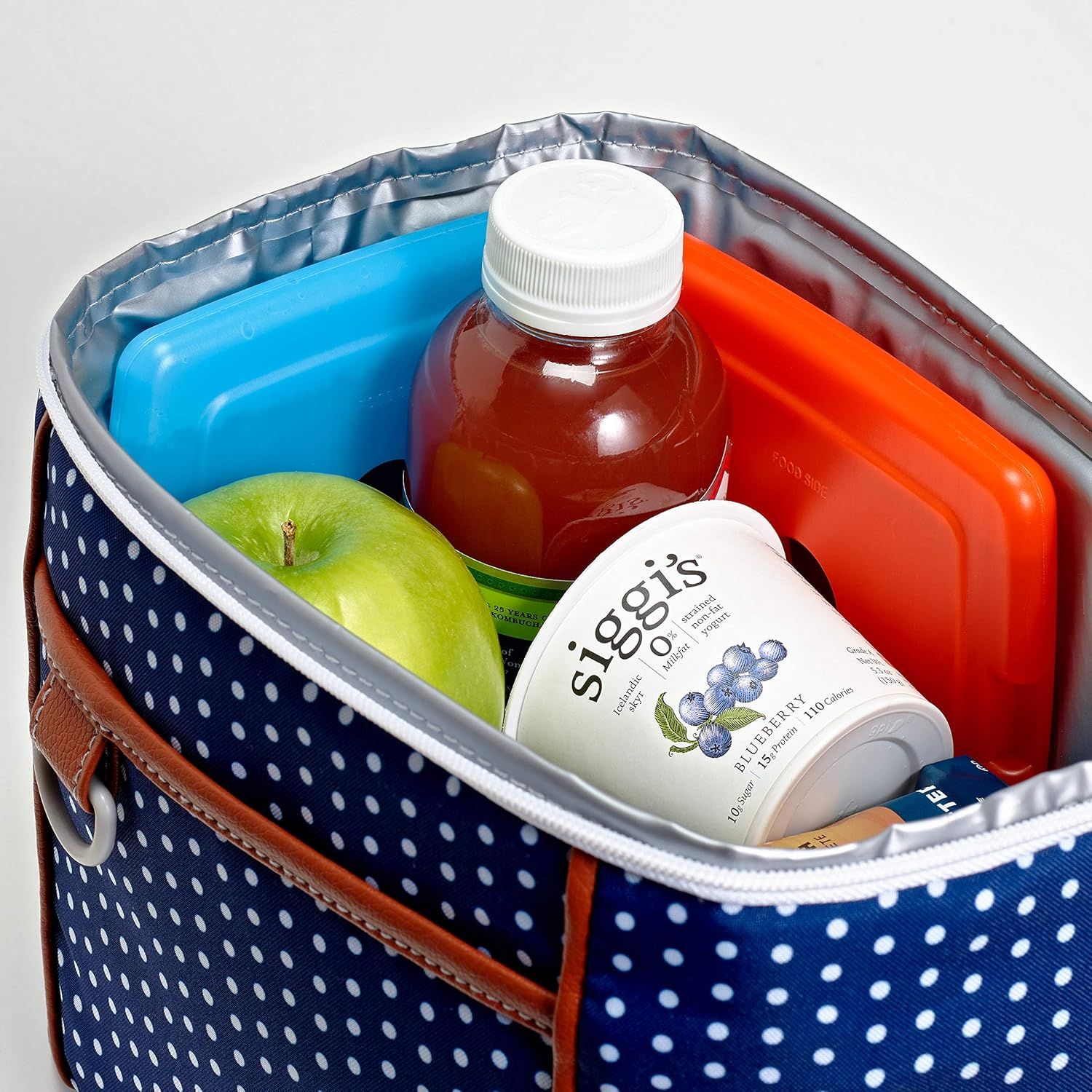 Demonstrates the product in a real-world context showing how it can be used to carry lunch items including drinks, snacks, and fresh fruit, helping shoppers…