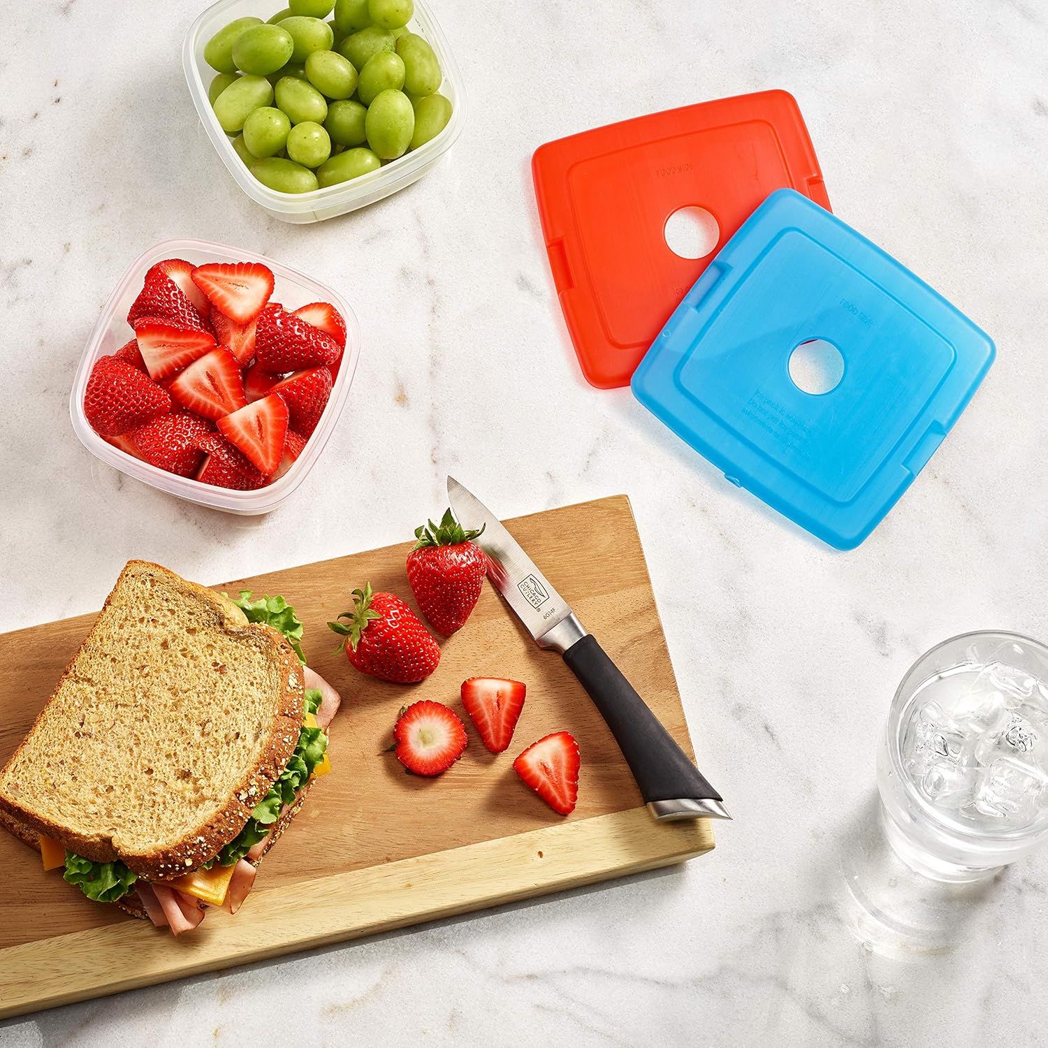 Demonstrates the product in a real-world meal prep context, showing the containers being used to store fresh fruits alongside a prepared lunch, helping…