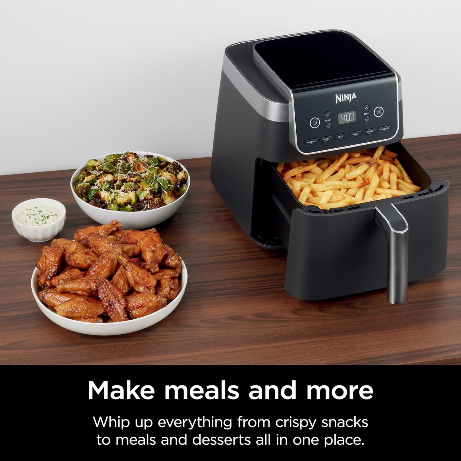 Demonstrates the air fryer's versatility by showing it can prepare multiple types of food (fries, chicken wings, Brussels sprouts) to reassure shoppers of its…