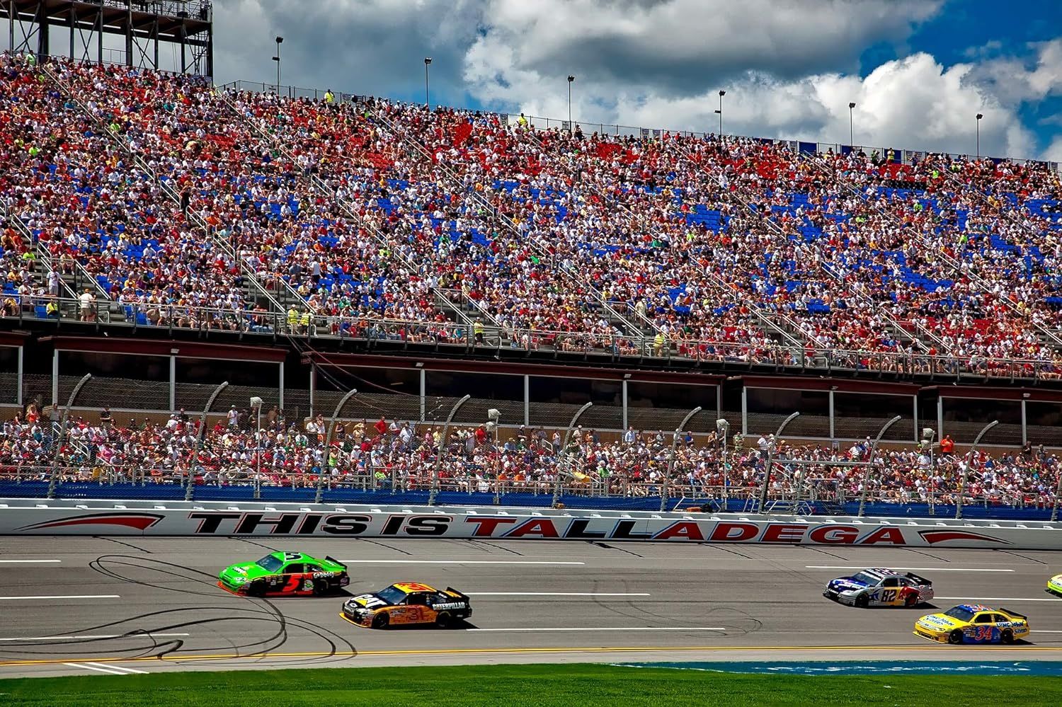 Demonstrates the product in a real-world racing environment at Talladega Superspeedway, showing the excitement and scale of the event to appeal to racing enthusiasts and convey authenticity.