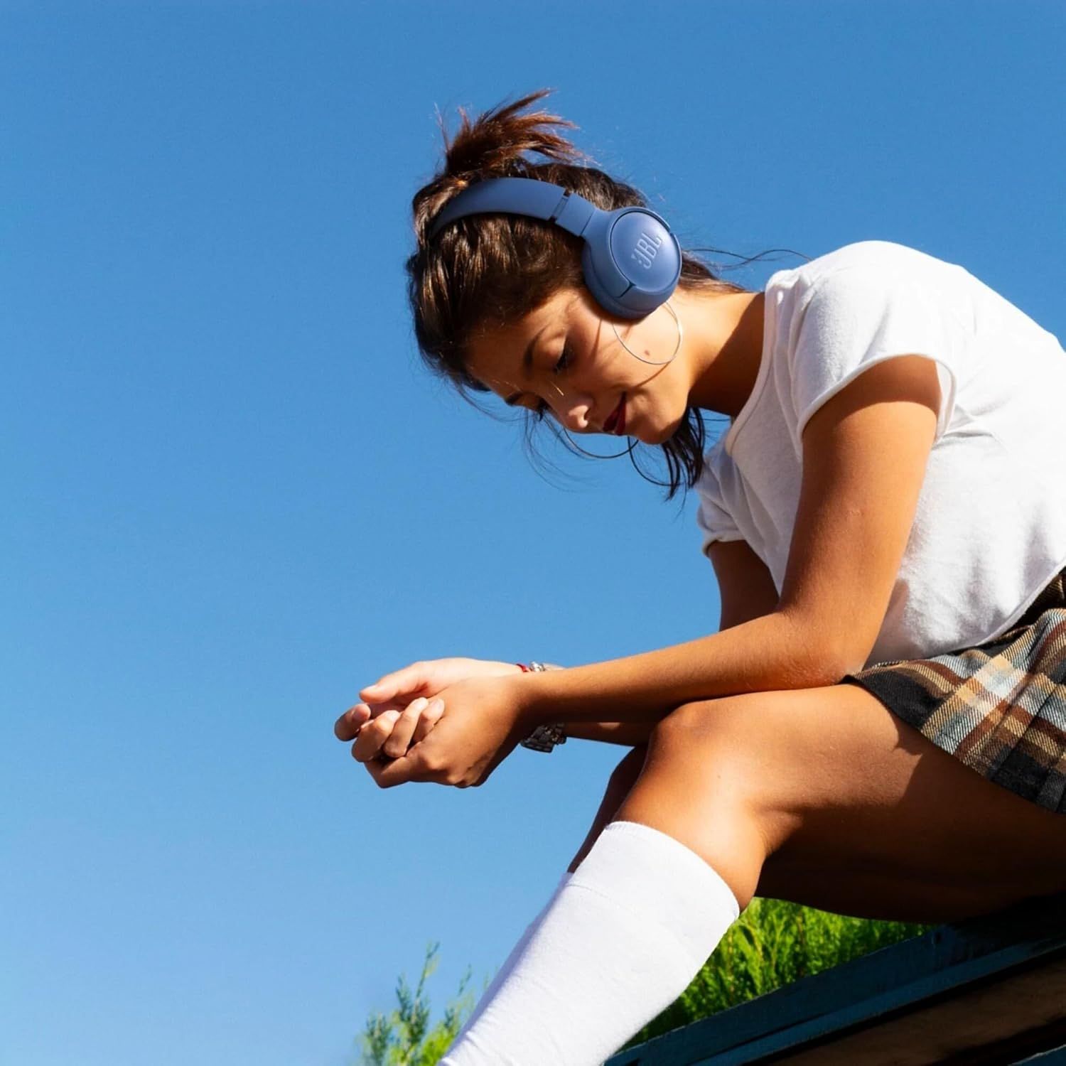 Demonstrates the product being used in a real-world outdoor athletic context to help shoppers visualize themselves using the headphones during active lifestyle moments.