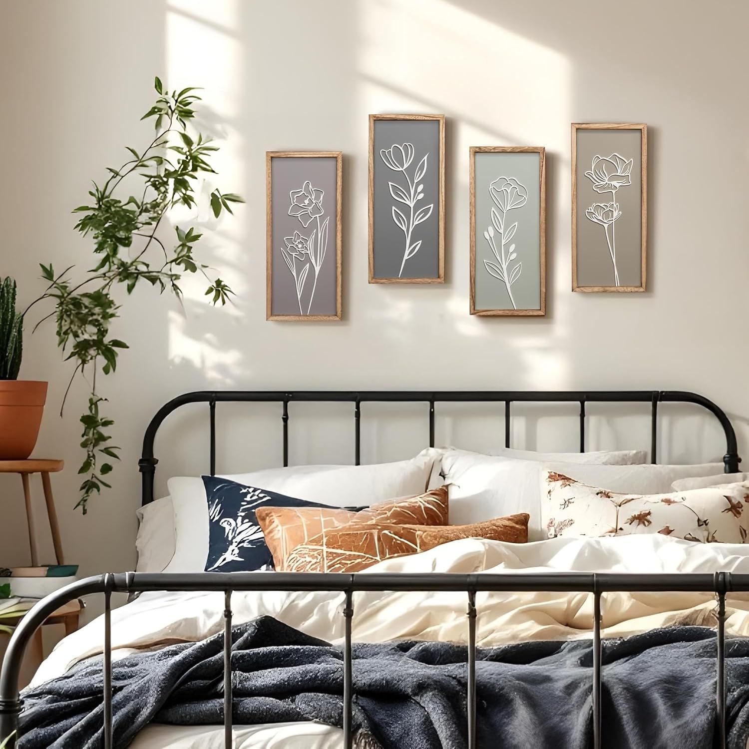 Showcases the product (wall art/framed botanical prints) in a real-world bedroom environment to help shoppers visualize how it would look in their own home.