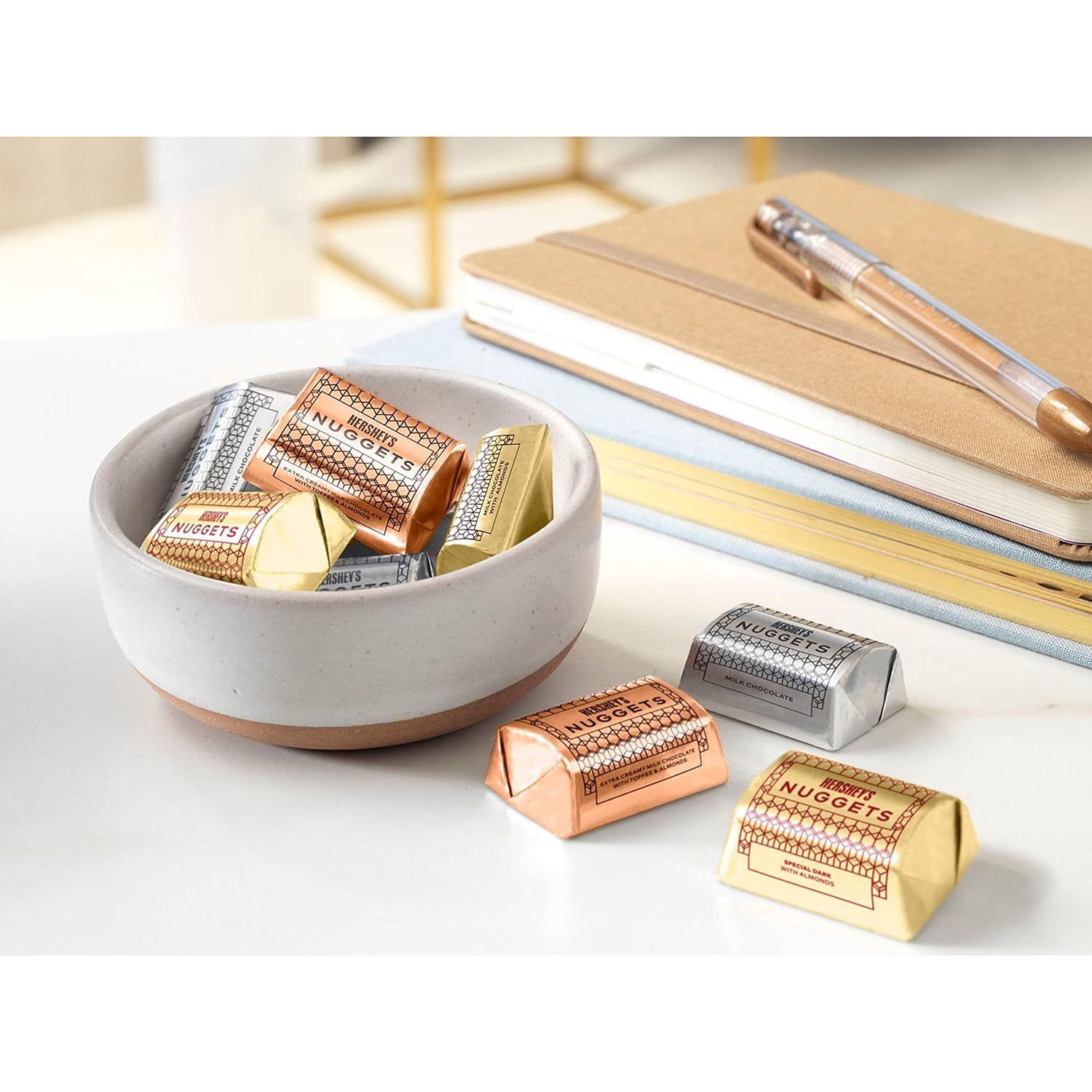 Showcases the product in a real-world office or desk setting to help shoppers visualize how the chocolates fit into their everyday environment.