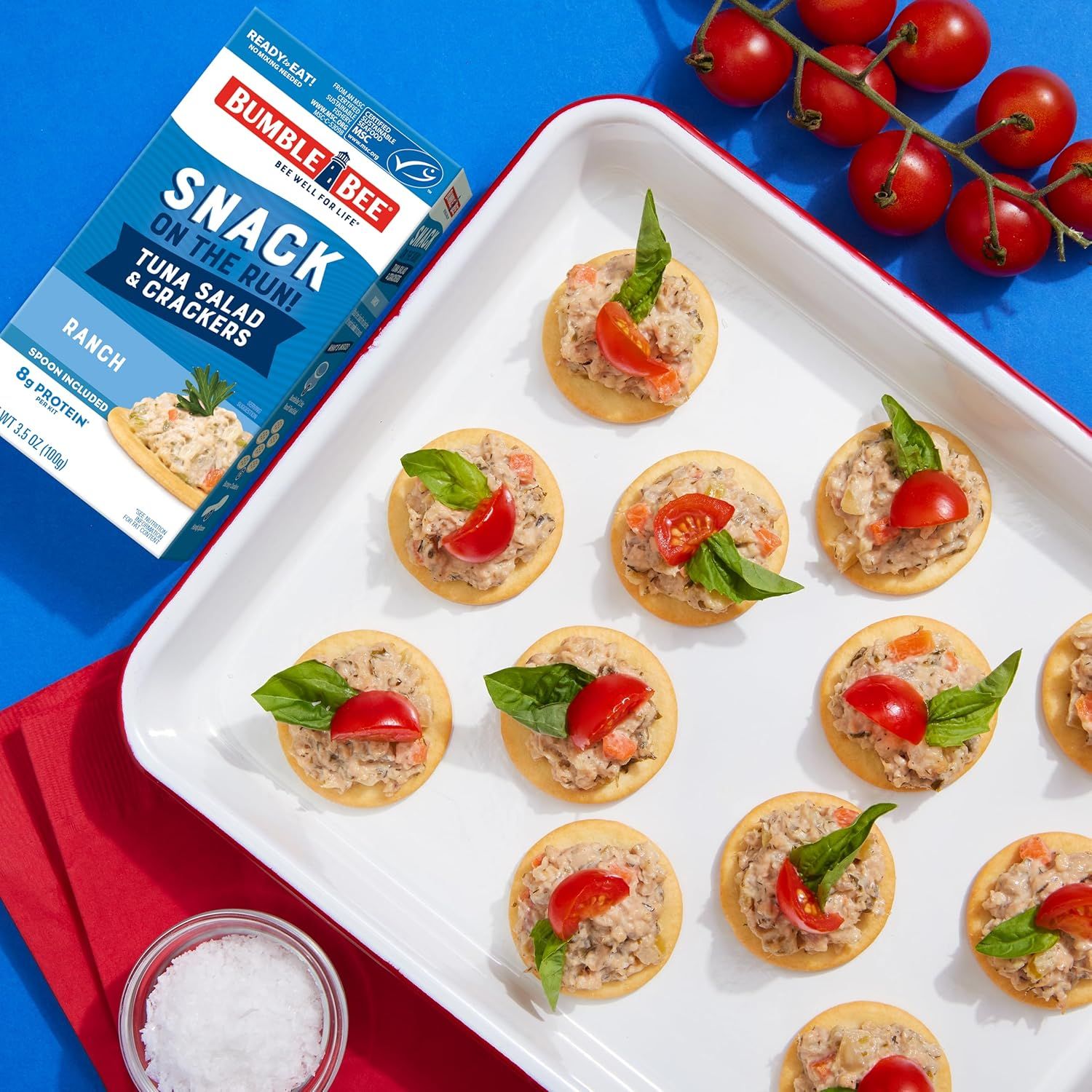 Demonstrates a creative serving idea for the tuna salad product, showing shoppers how to use it as an appetizer on crackers to inspire purchase and usage.
