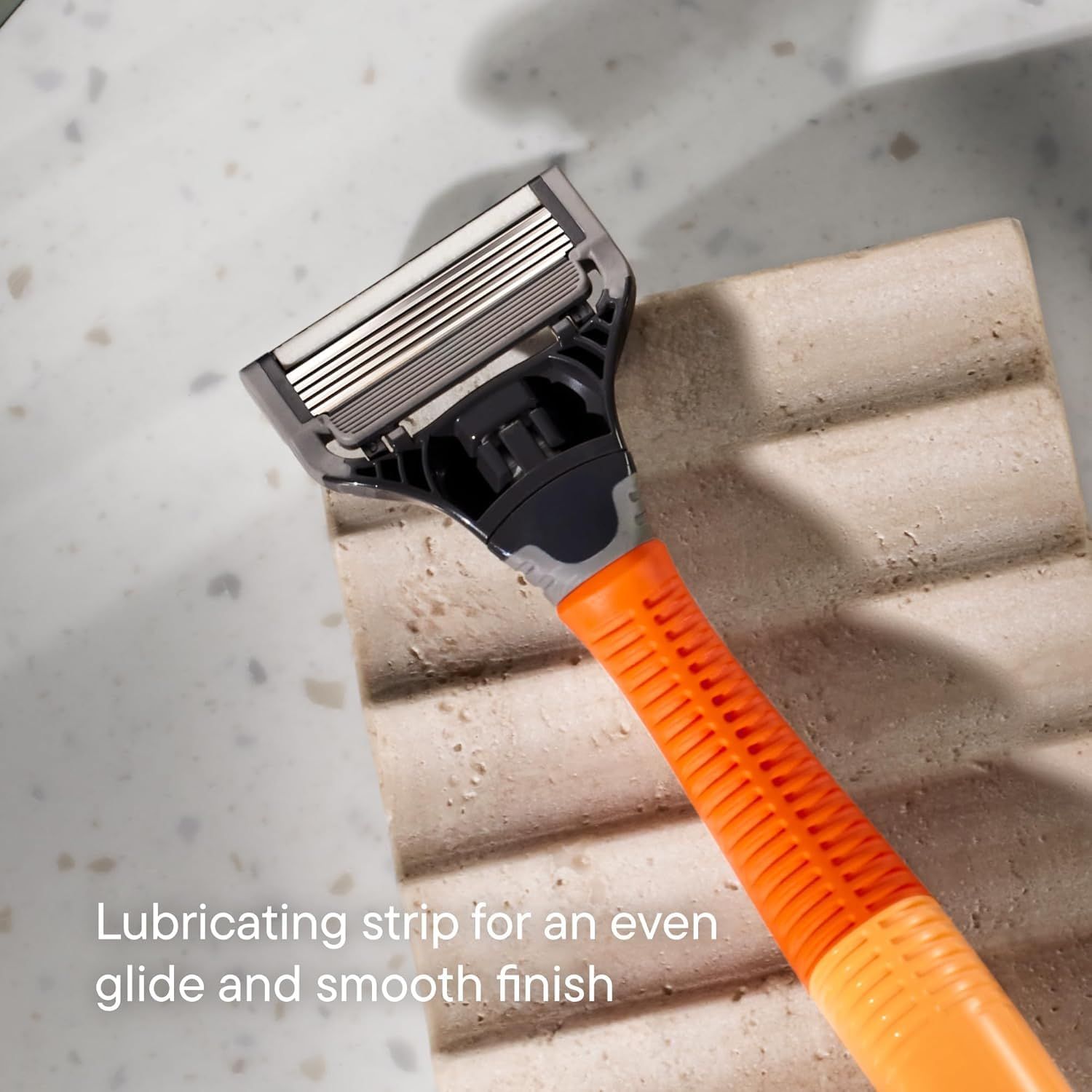Highlights the lubricating strip feature of the razor to communicate that it provides an even glide and smooth finish during shaving. Communicates the benefit…