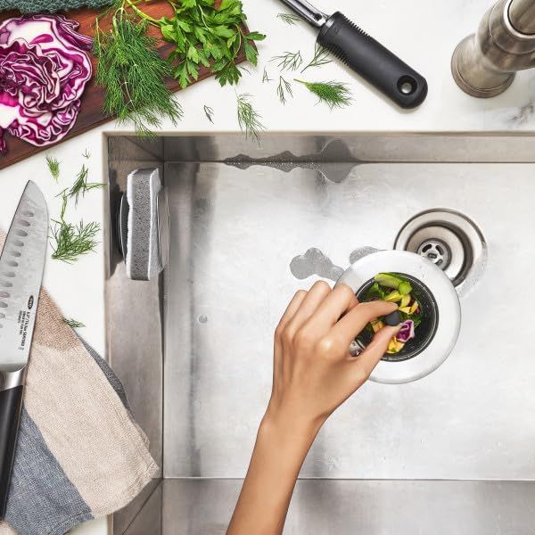 Demonstrates the product in a real-world kitchen environment, showing how food scraps are disposed of in the sink, creating an authentic and relatable usage context.