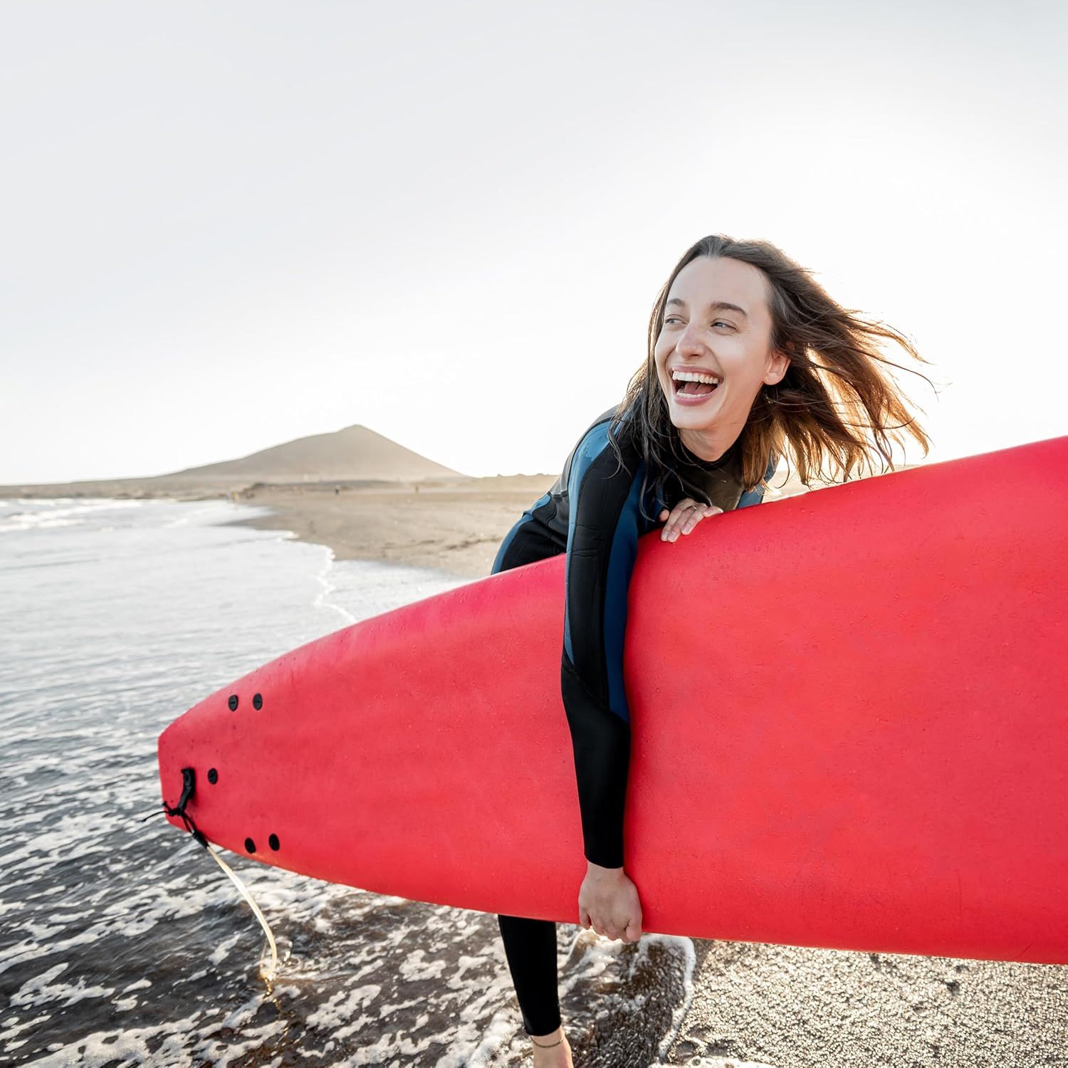 Showcases the product in an authentic real-world beach setting to help shoppers visualize themselves using it for surfing or water sports, creating emotional connection and aspiration.