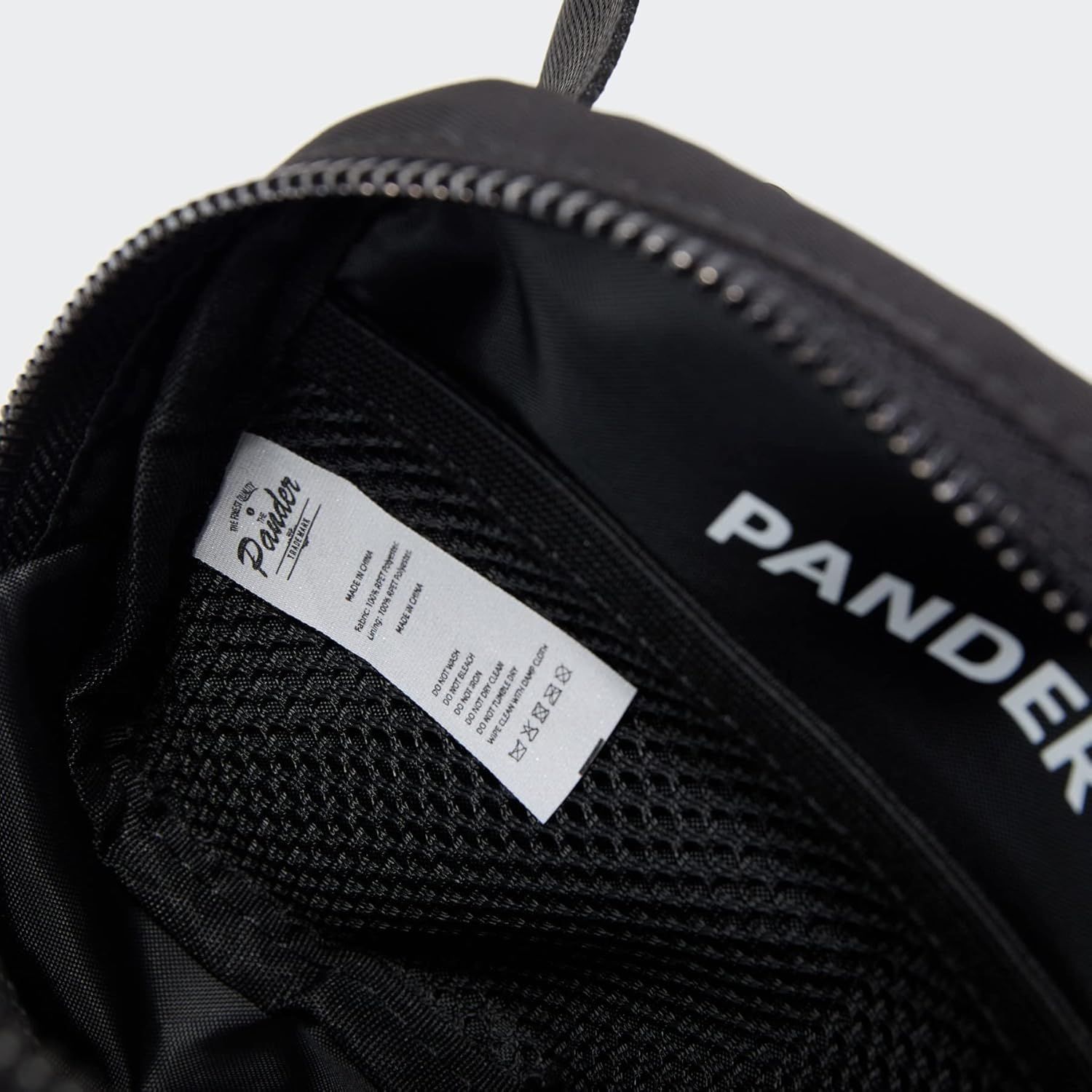 Shows the interior construction and branding details of the product, highlighting the quality label and zipper mechanism to communicate craftsmanship and…