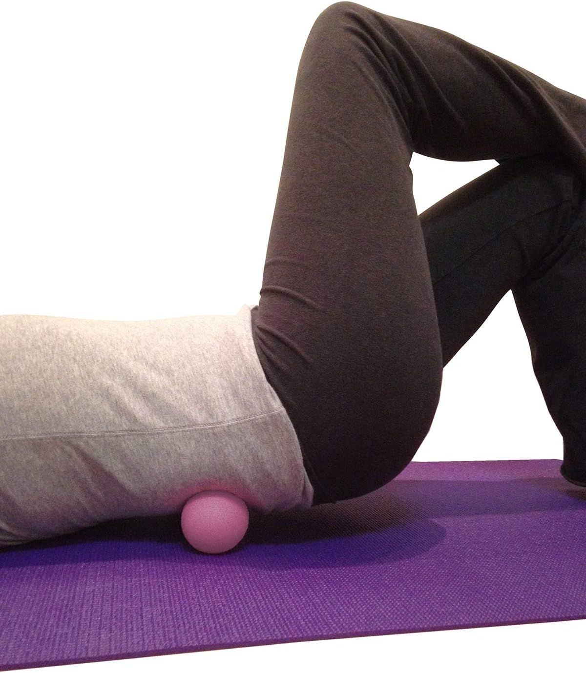 Shows the product being used in a real-world yoga or fitness context to help shoppers visualize how the massage ball works during exercise or stretching routines.