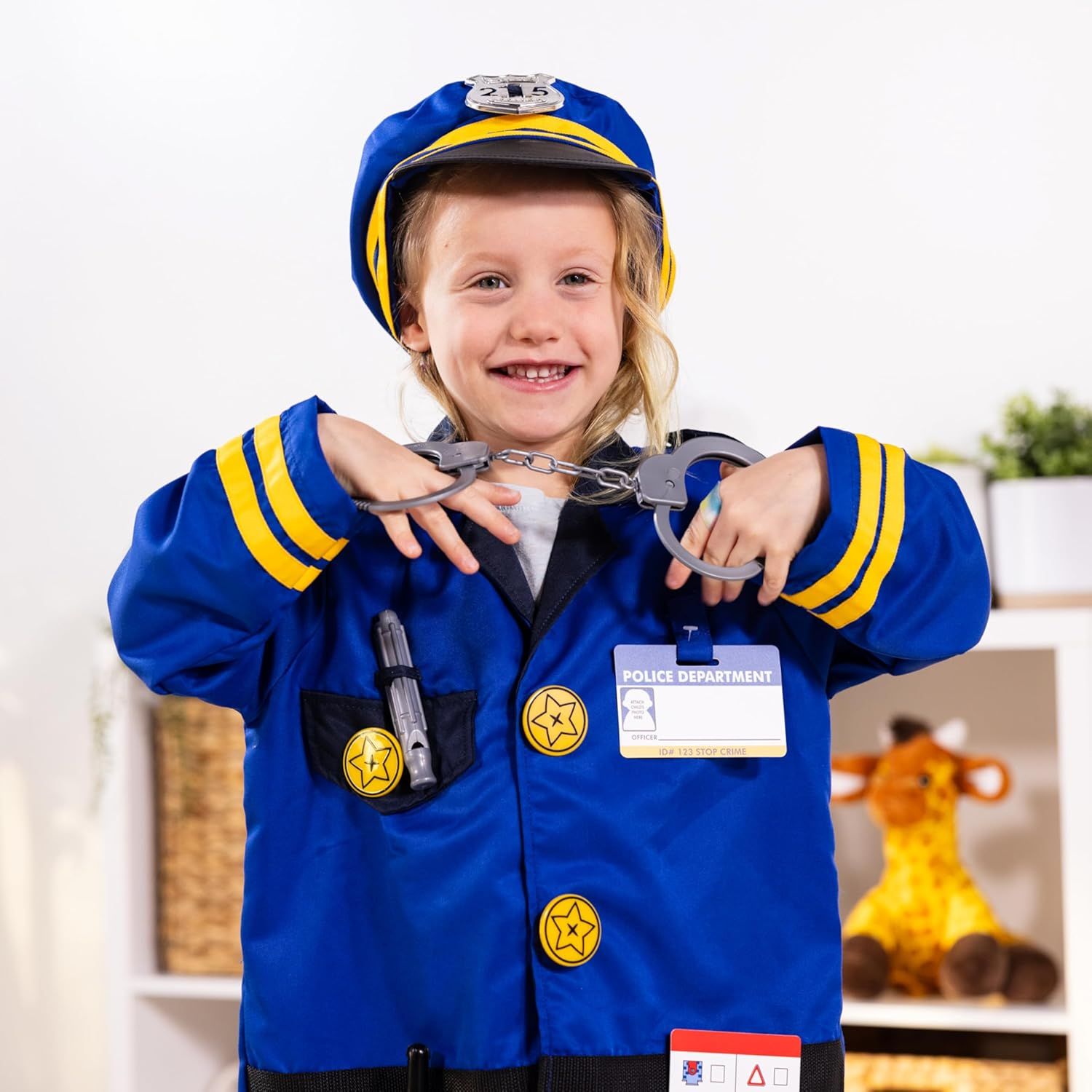 Shows the child wearing the complete police costume set with included accessories like handcuffs, badge, ID card, and hat to demonstrate what customers receive and how the product looks when worn.