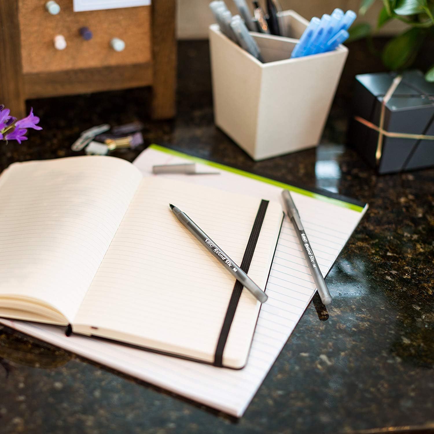 Showcases the product in a real-world home or office environment to help shoppers visualize how the notebooks and pens would fit into their daily workspace or…