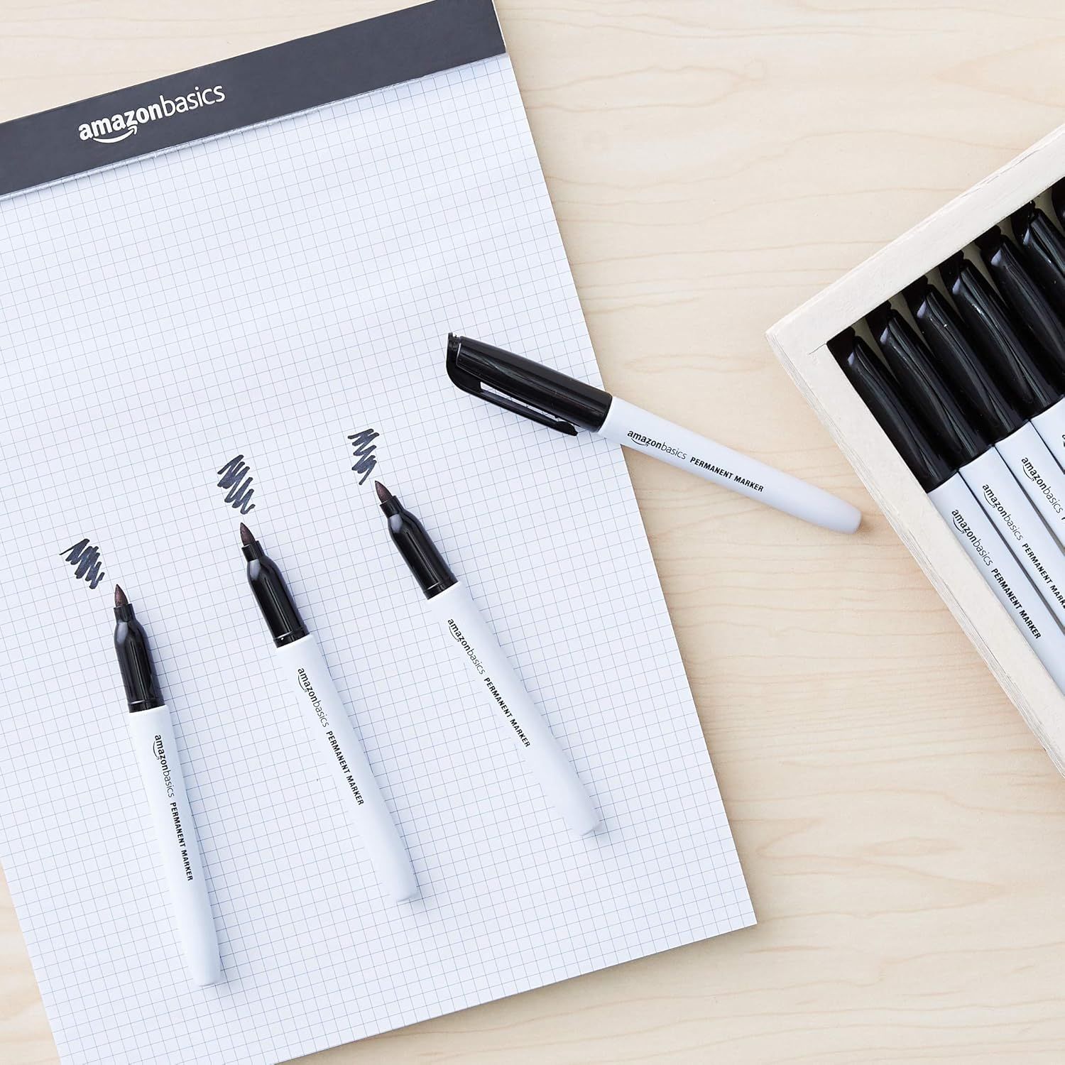 Shows the customer what comes in the package: multiple permanent markers and an AmazonBasics notepad, demonstrating the value and completeness of the set.