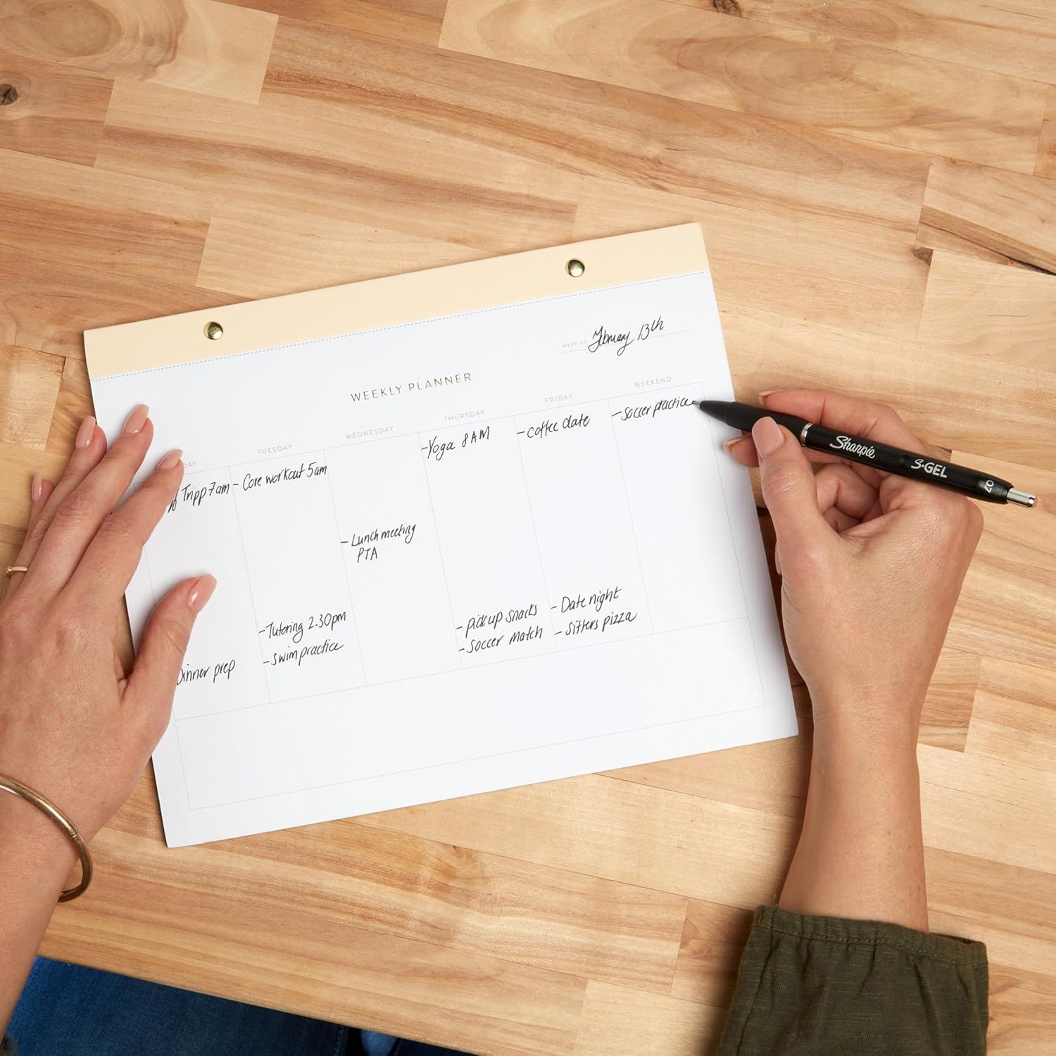 Demonstrates the product in a natural, everyday context to help shoppers visualize how they would use the weekly planner in their own life.