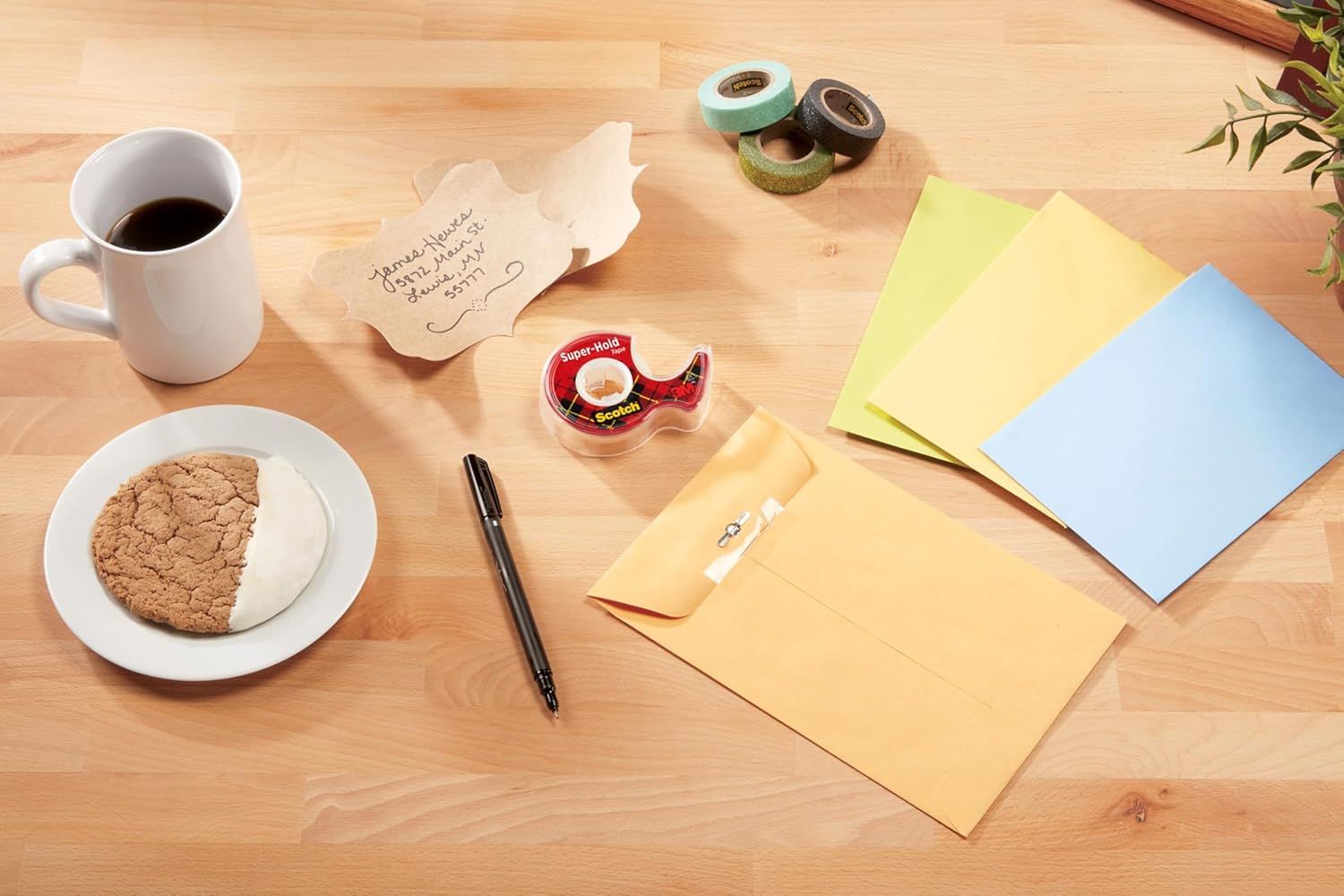 Shows the Scotch tape dispenser in a real-world office or home workspace context to help shoppers visualize the product in everyday use.