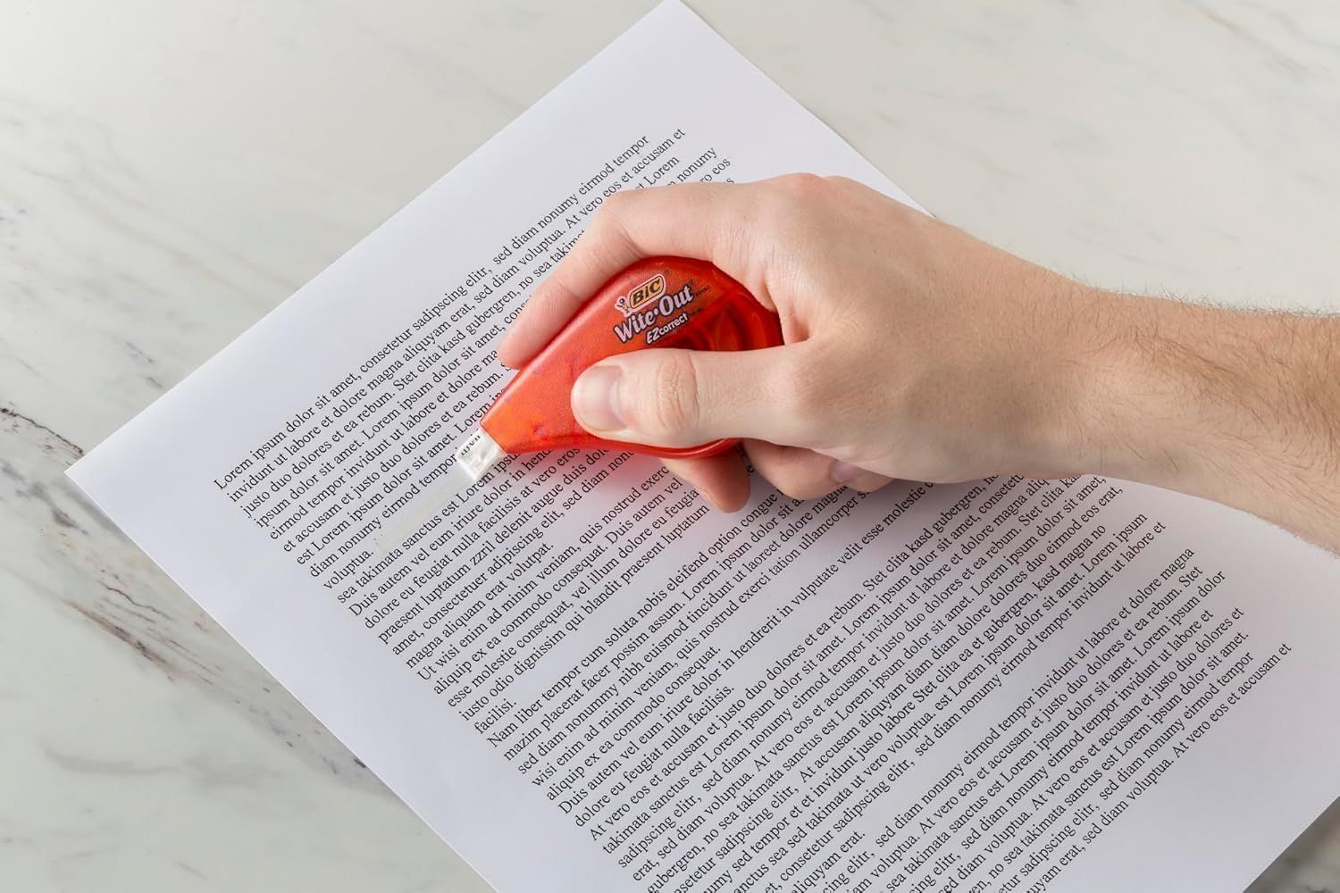 Demonstrates how to use the Wite-Out correction tape on printed text, showing the product in action to reassure shoppers of its ease of use and practical application.
